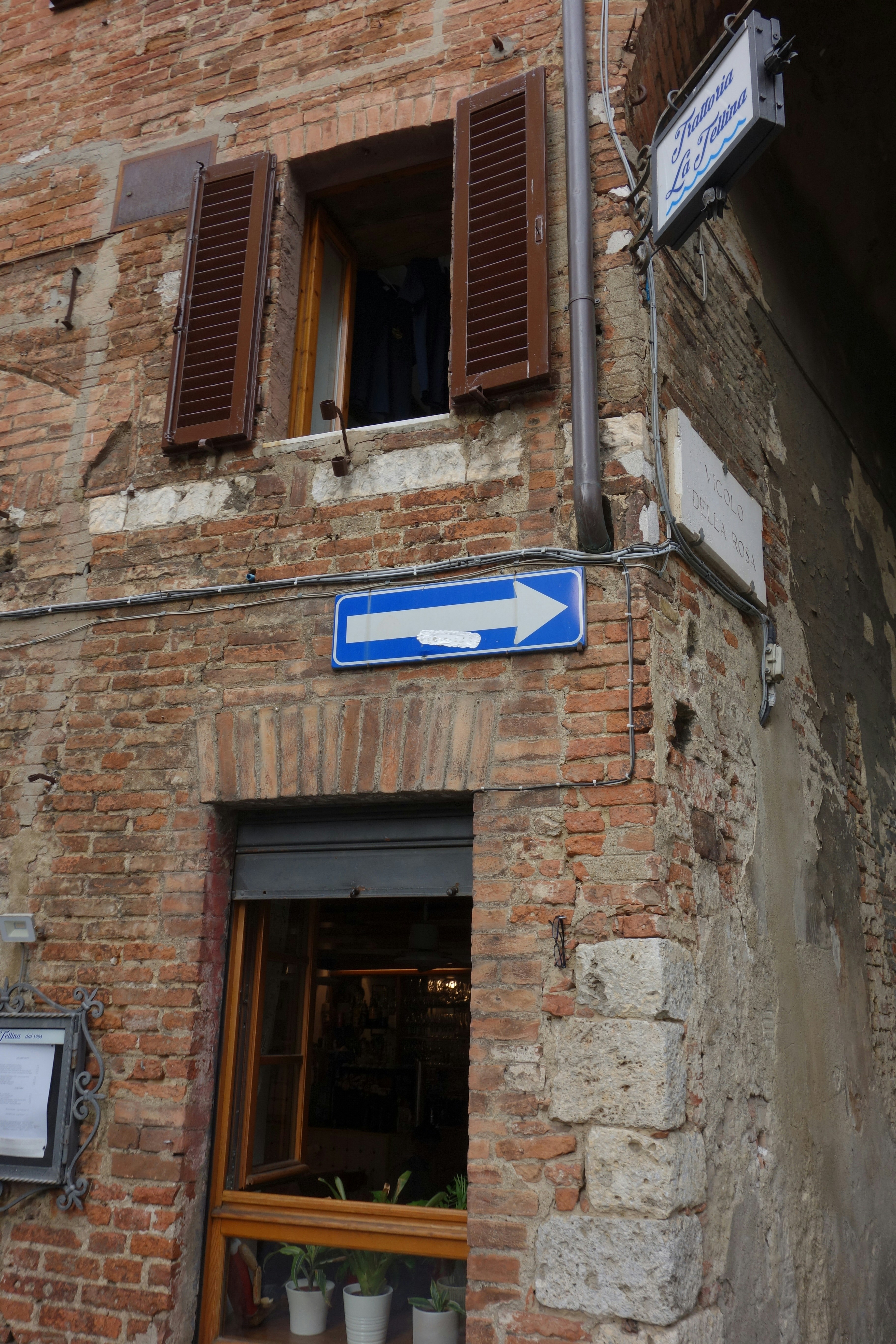 Brick building with window and one-way sign