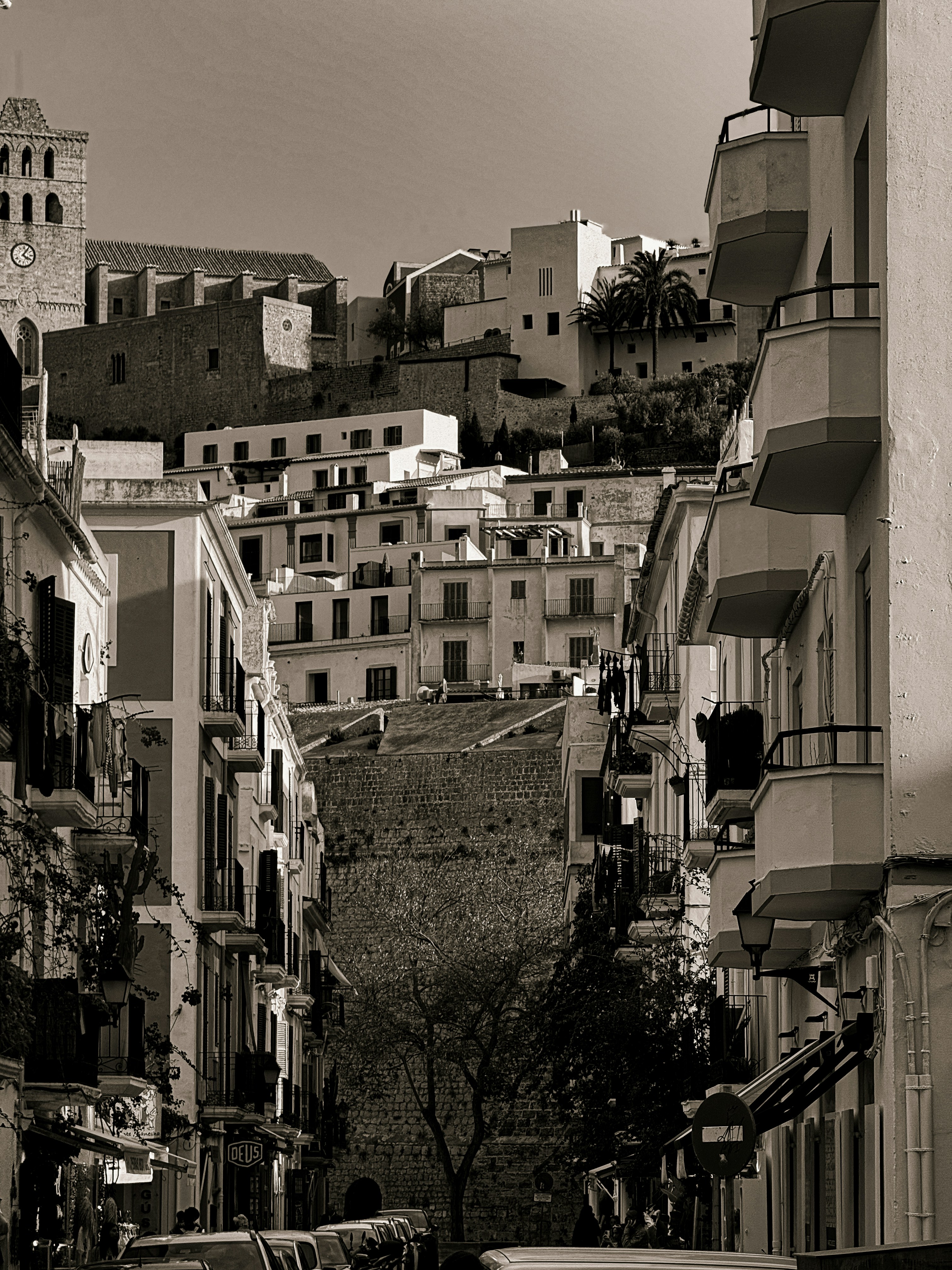 언덕에 하얀 건물이 있는 좁은 거리.