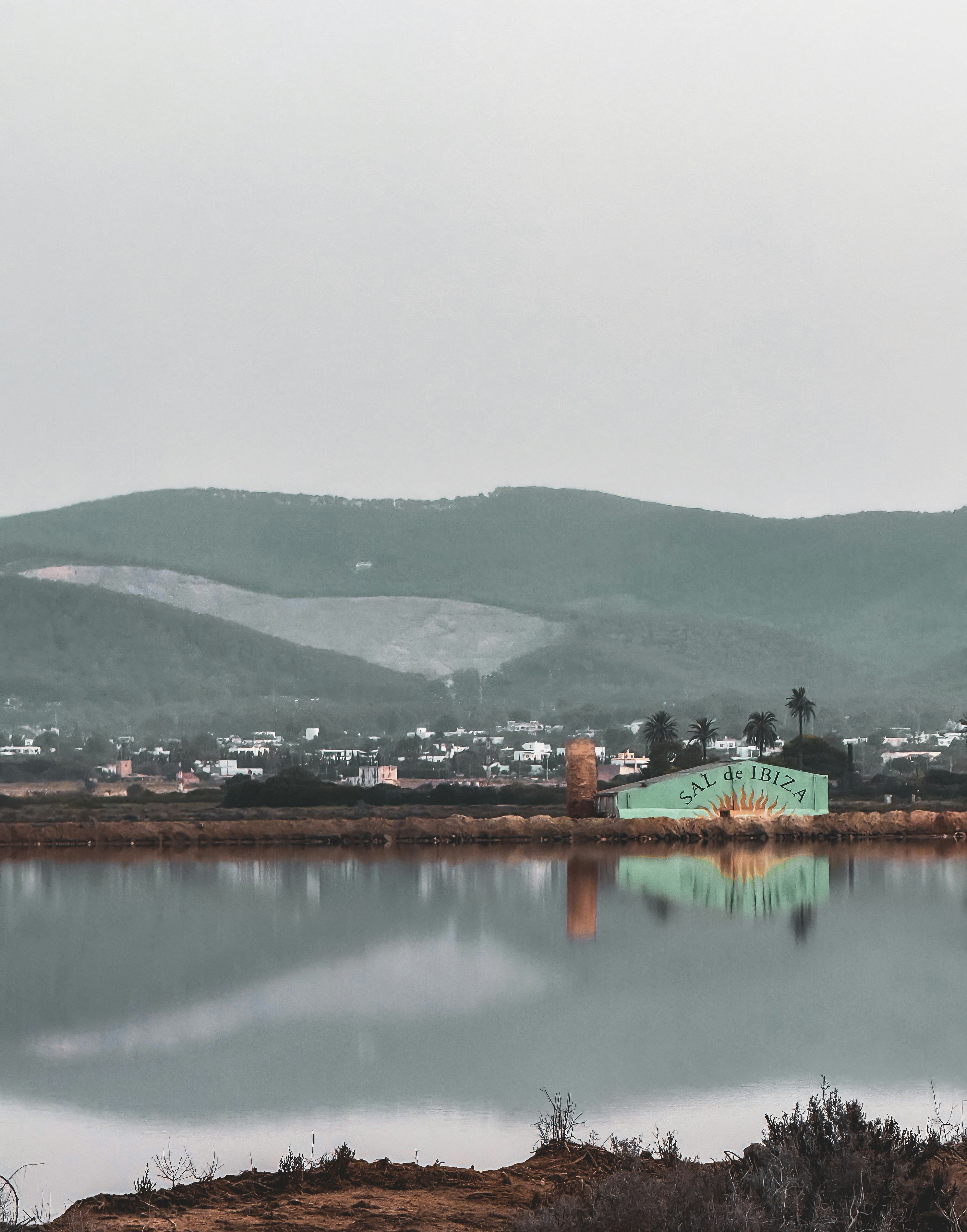 잔잔한 물에 비친 청록색 건물.