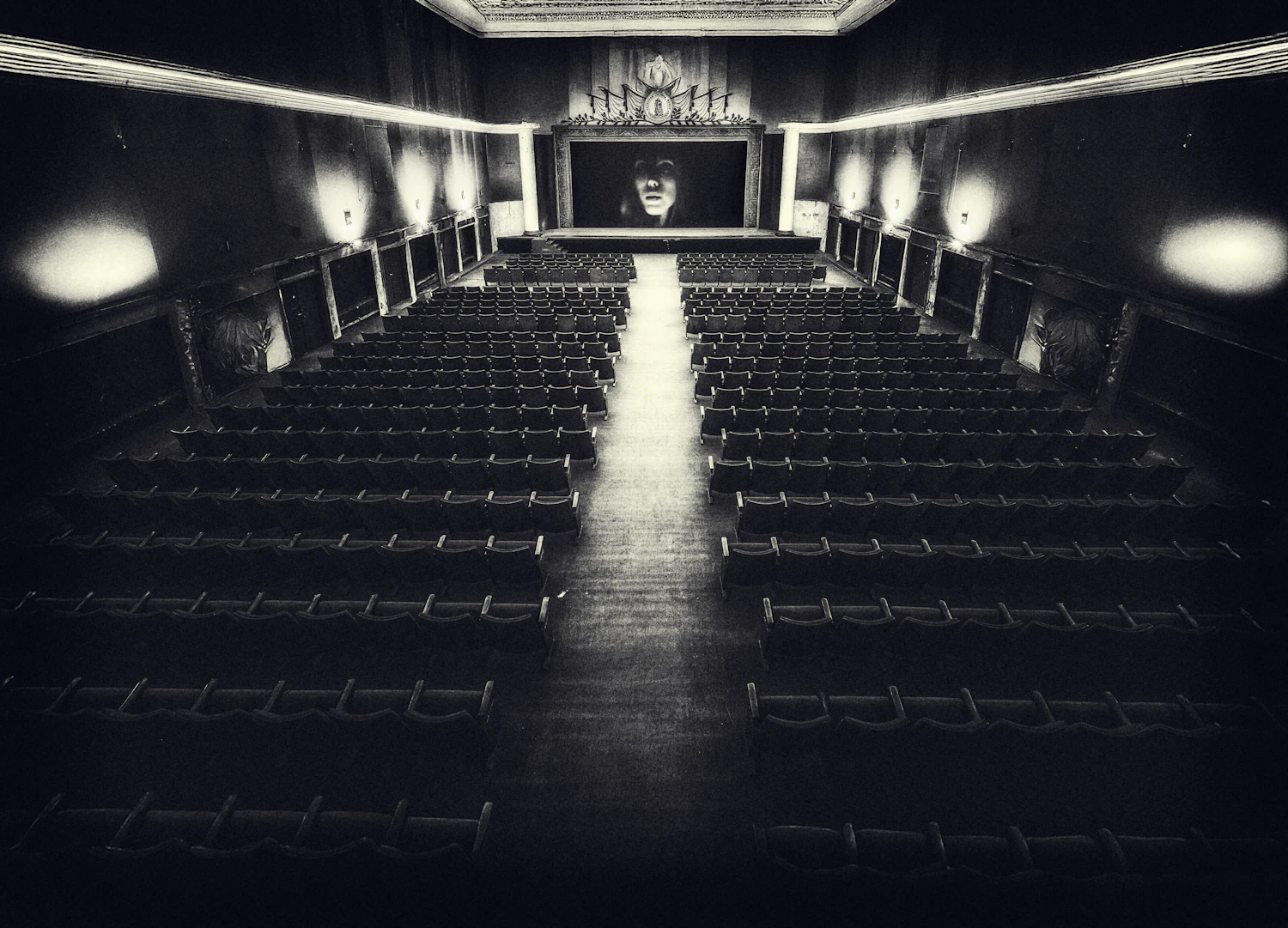 An empty auditorium with its house lights on, seen from the stage