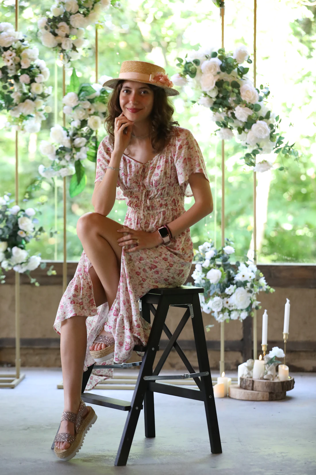 Model in a blush floral dress on a flower-covered swing