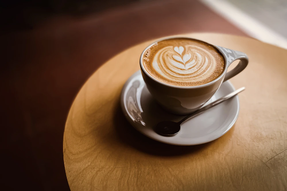 A latte with delicate latte art on a saucer