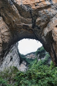 Natural rock archway with lush green foliage below