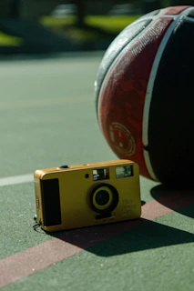 A gold camera and basketball on a court