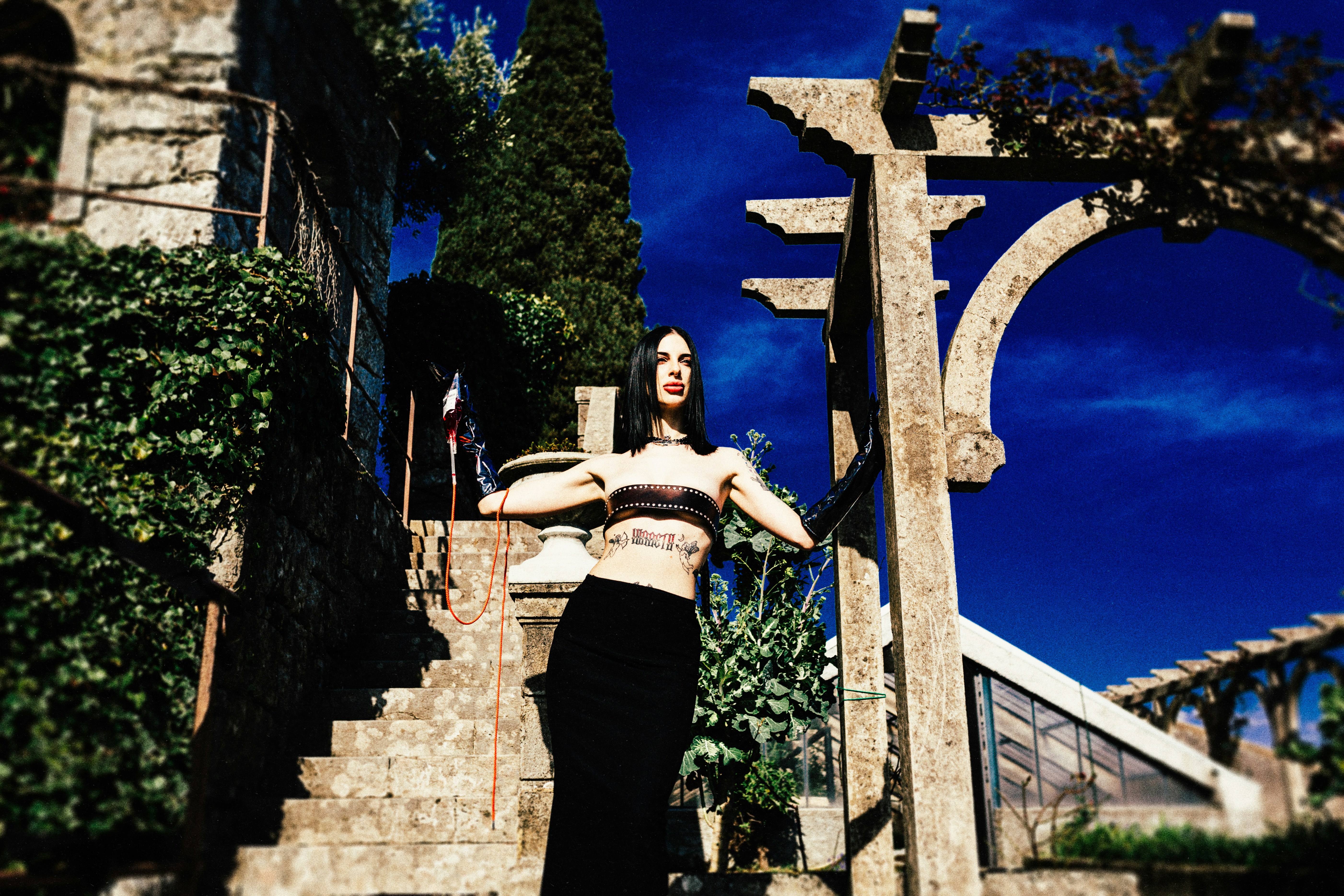 Woman posing on stone steps with pergola