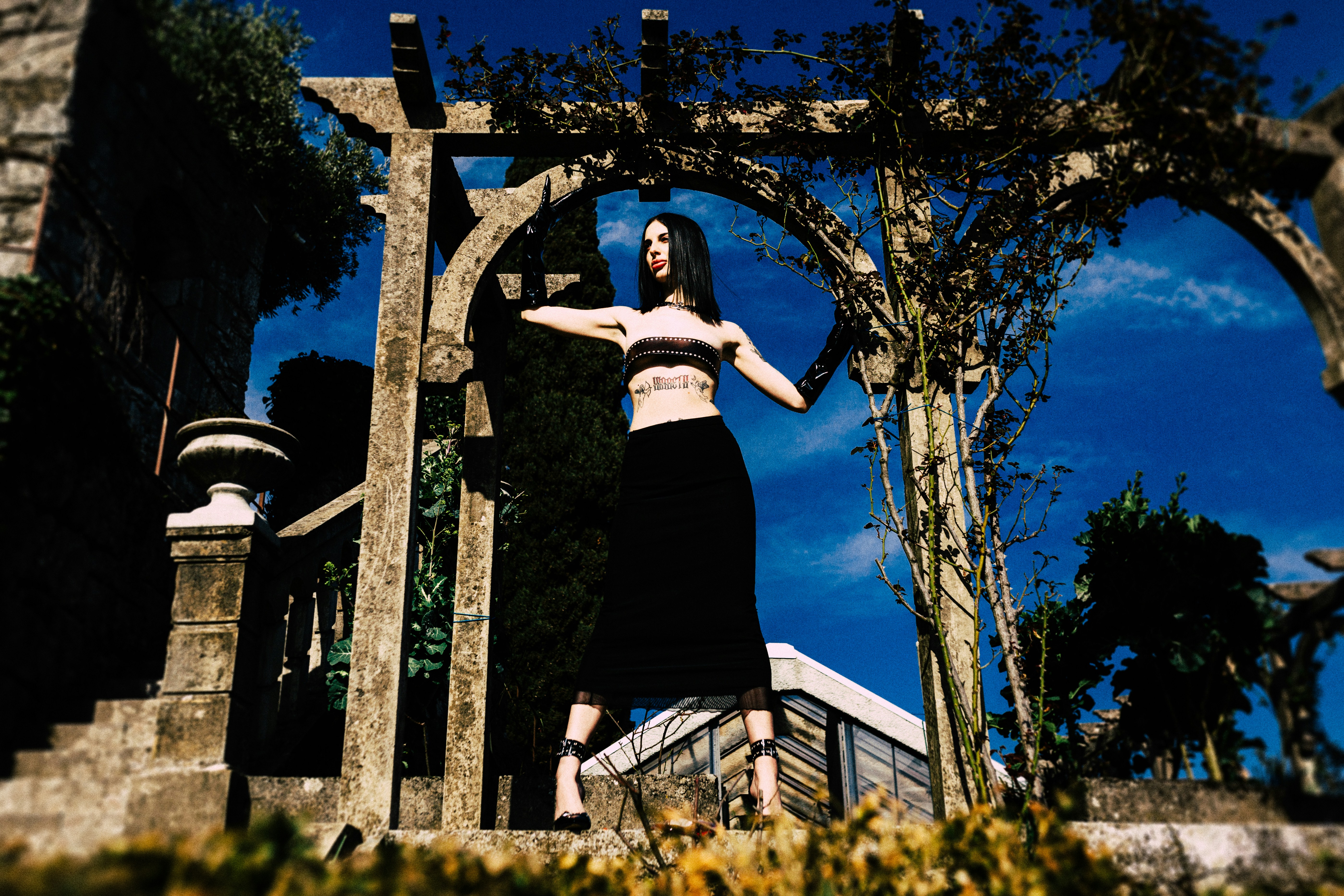 Woman standing in stone archway with blue sky