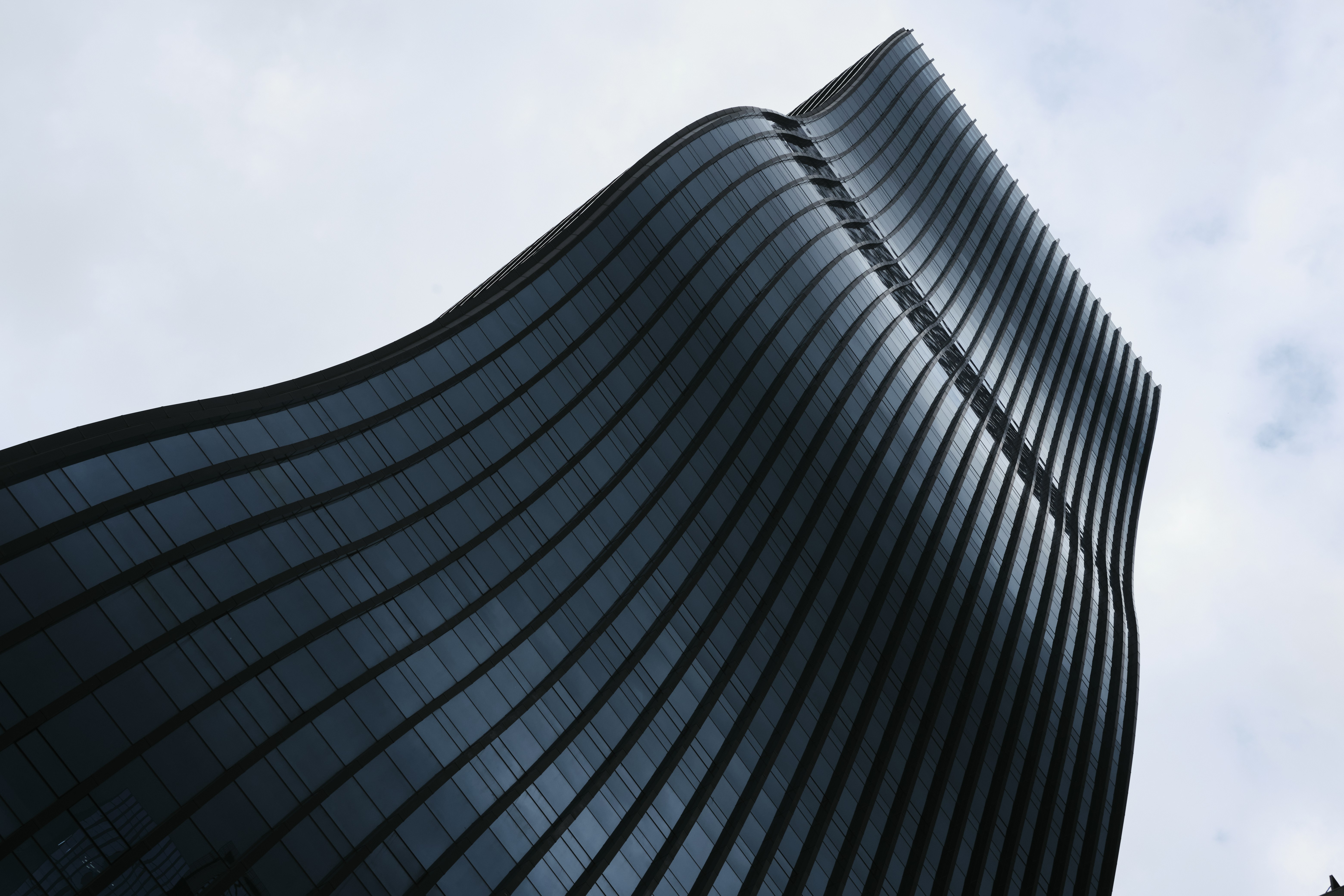 Modern curved building against a cloudy sky