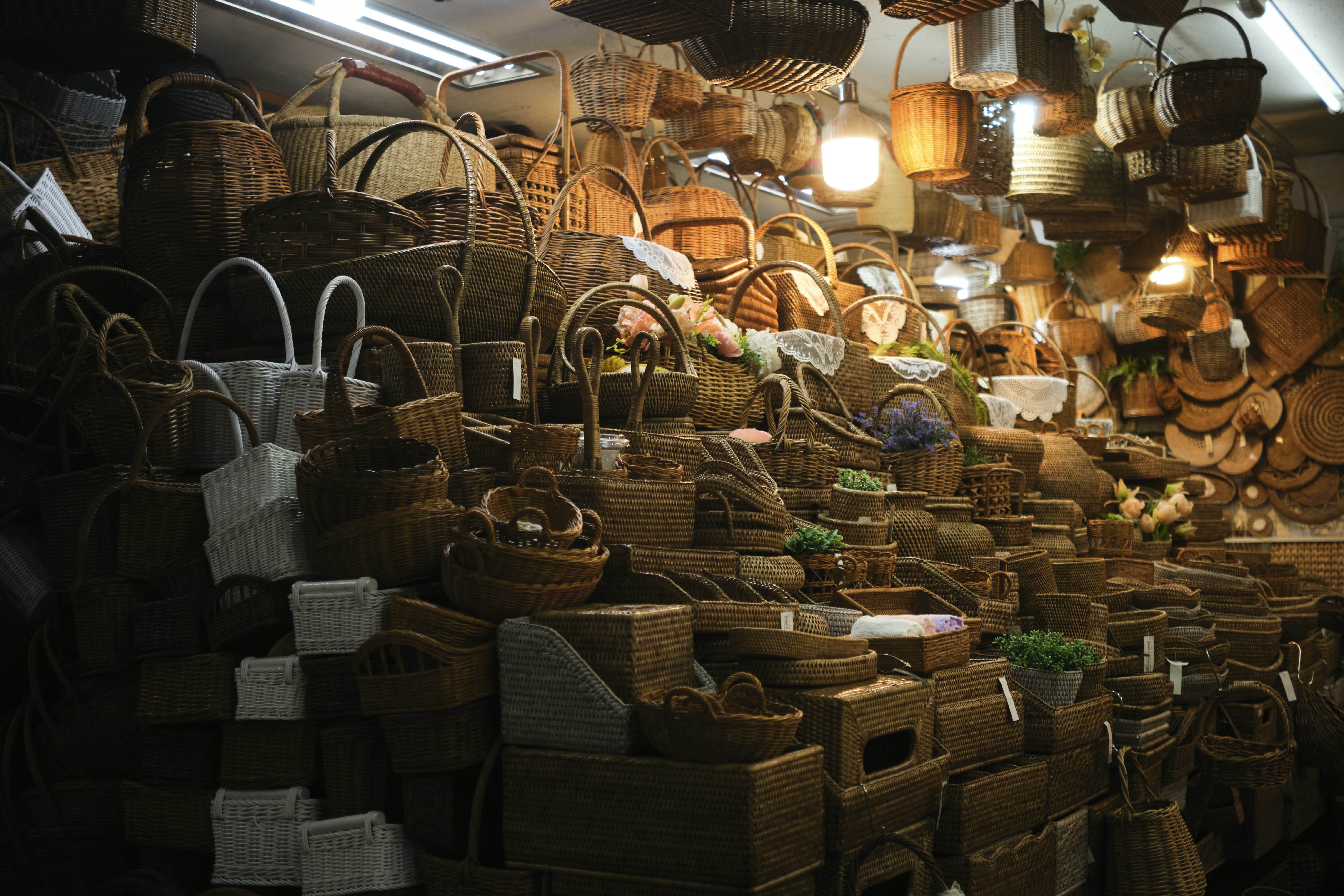 A stall filled with various woven baskets and wooden crafts.
