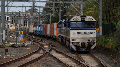 A freight train with shipping containers on tracks.