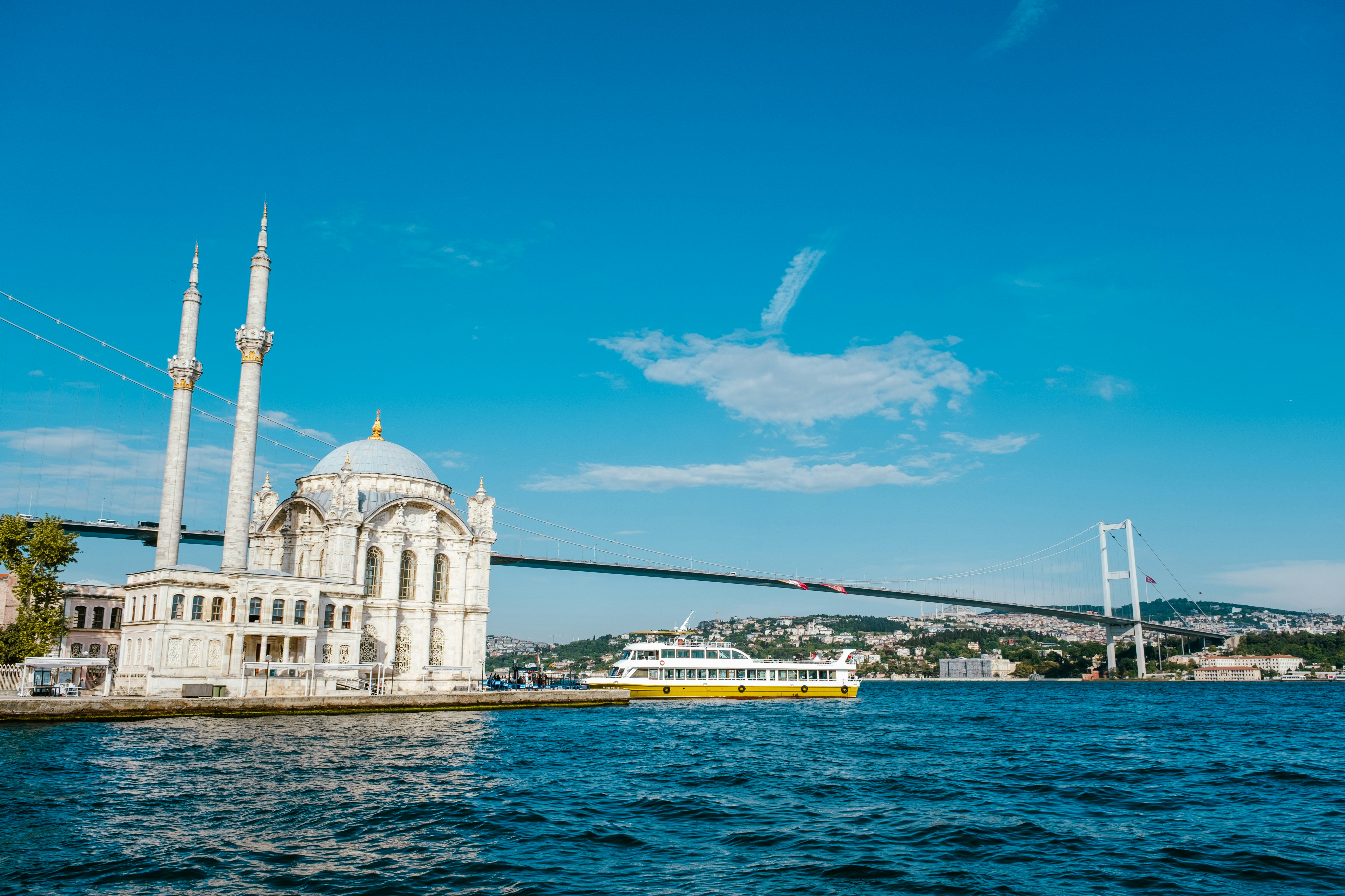 Mosque and bridge over blue water with boat