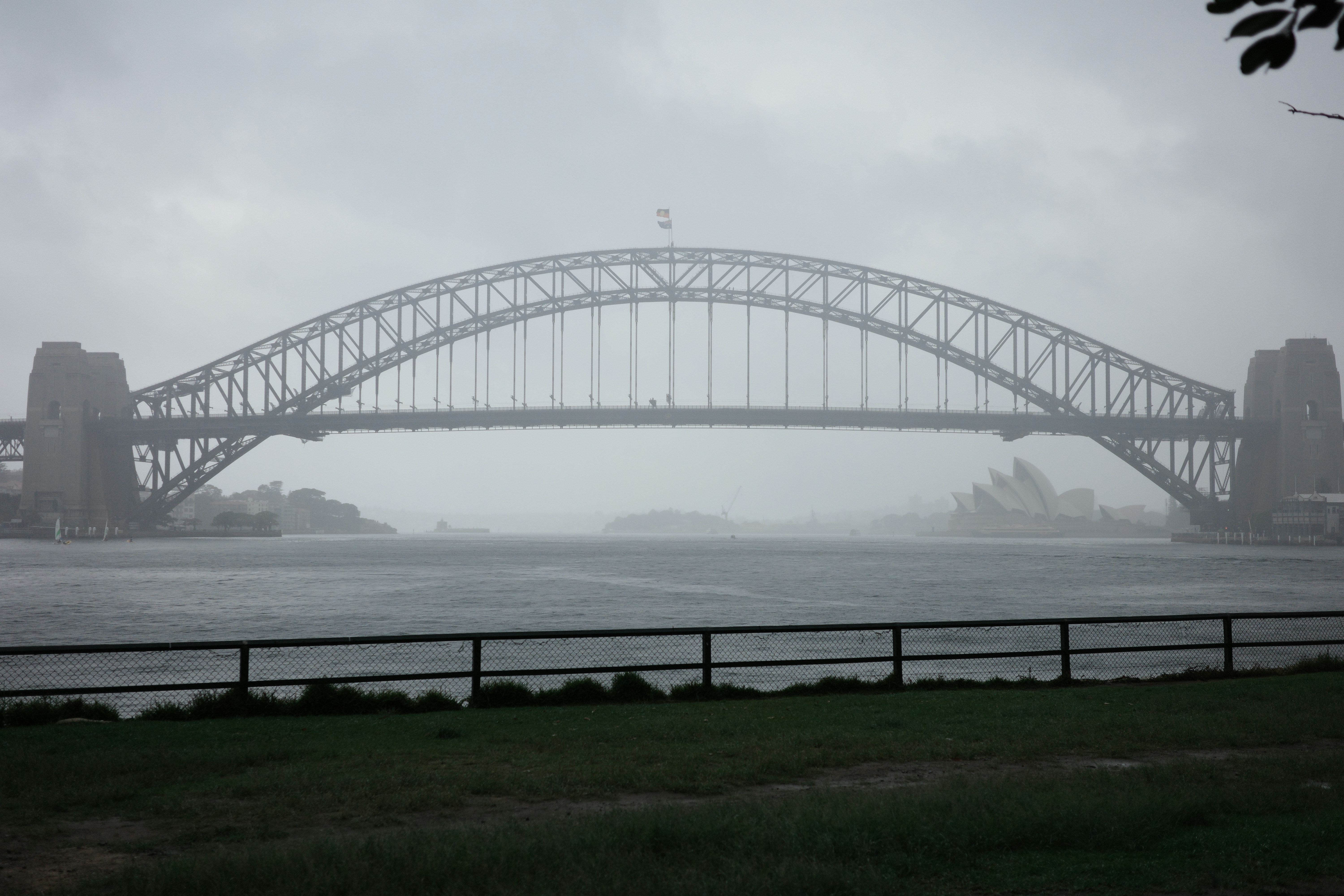 Un grande ponte d'acciaio si inarca su una campata nebbiosa.