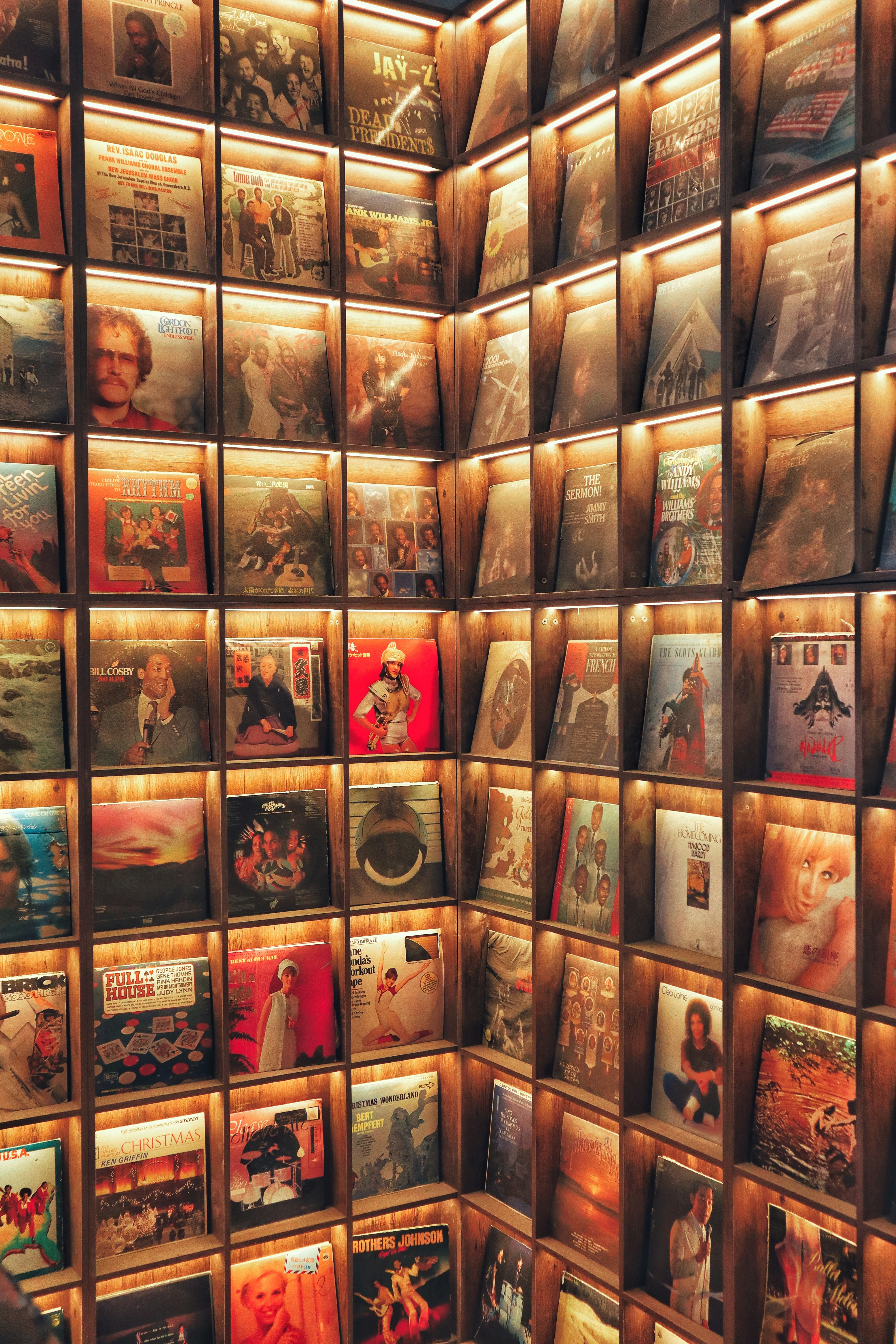 Wall of vintage vinyl records displayed in wooden shelves.