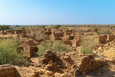 Ancient ruins of stone buildings in a dry landscape.