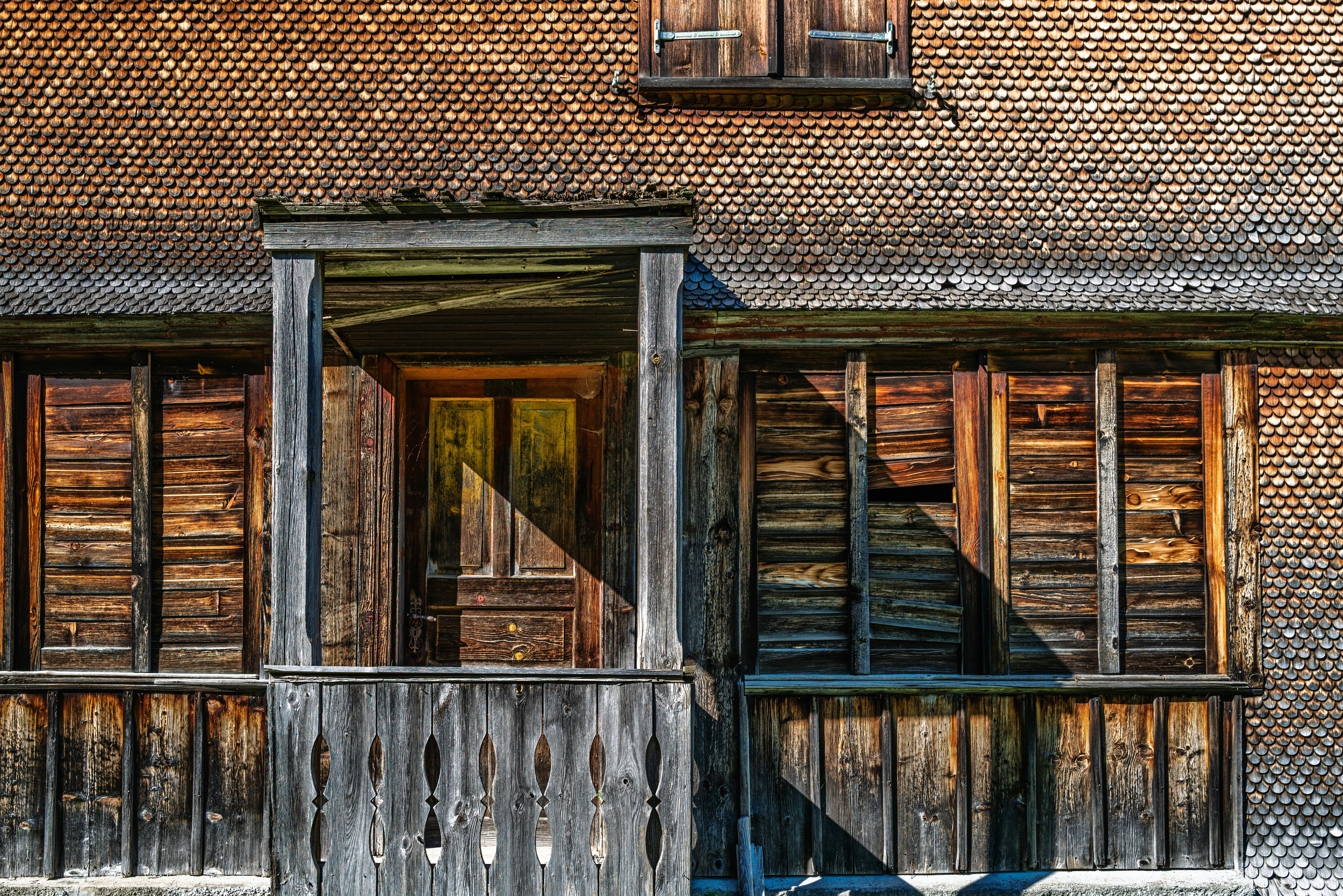 Old wooden house with weathered porch and shutters