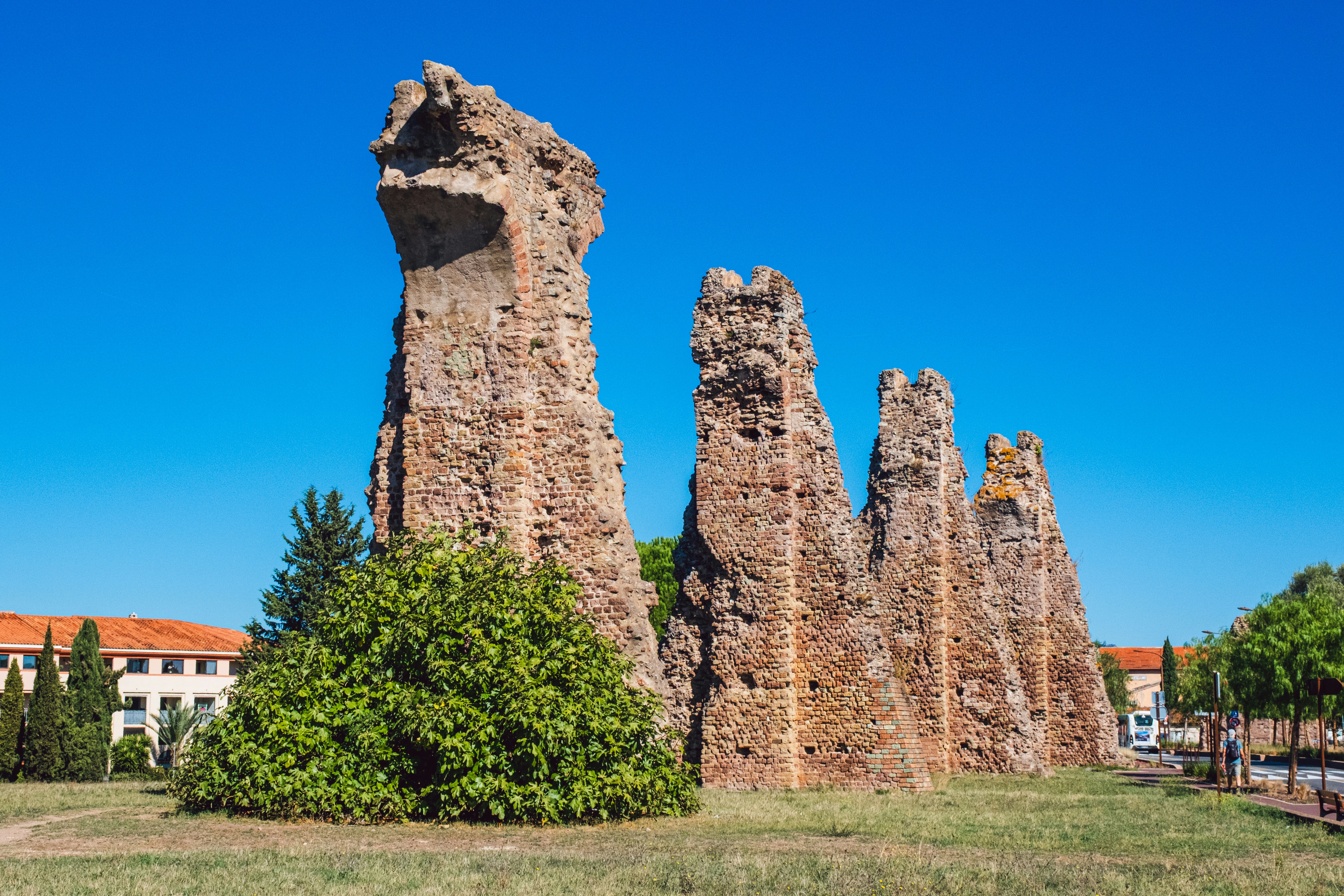 Ancient roman aqueduct ruins against a clear blue sky