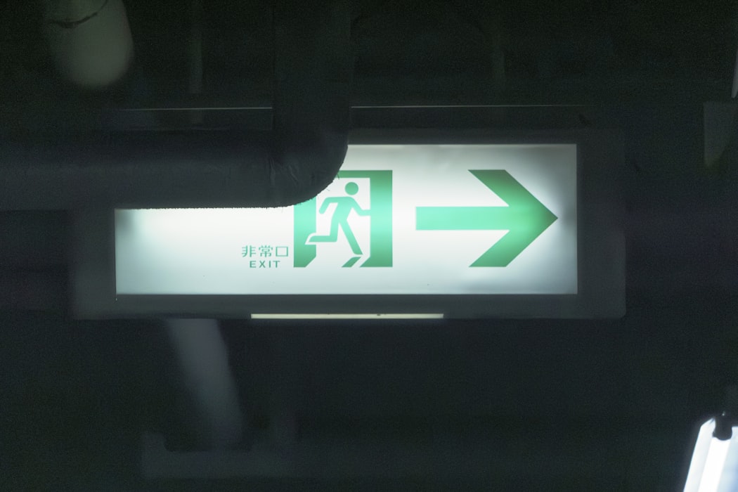 Green emergency exit sign with running person icon - standard safe condition sign required in all buildings
