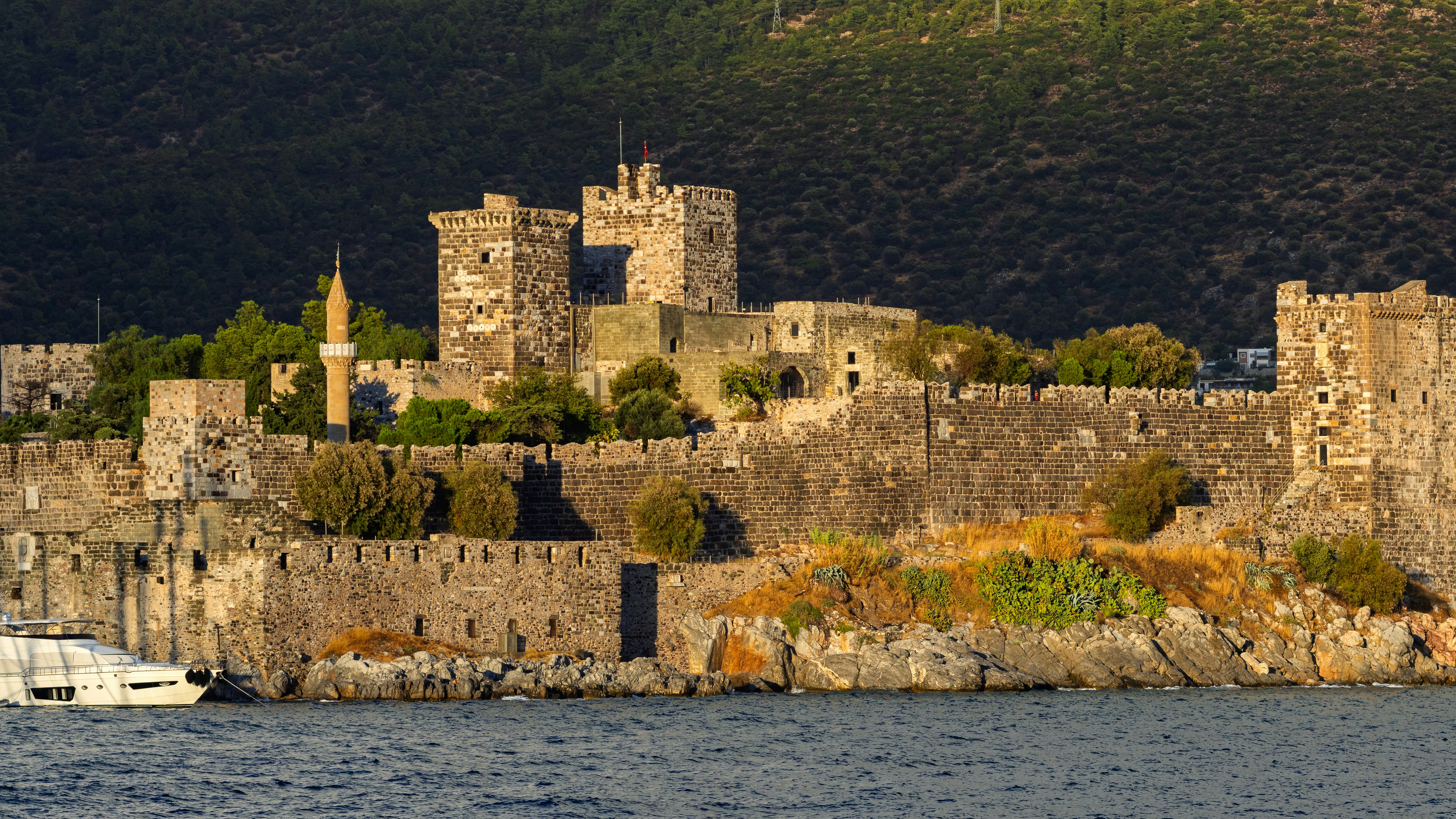 Ancient stone castle with a minaret by the sea.