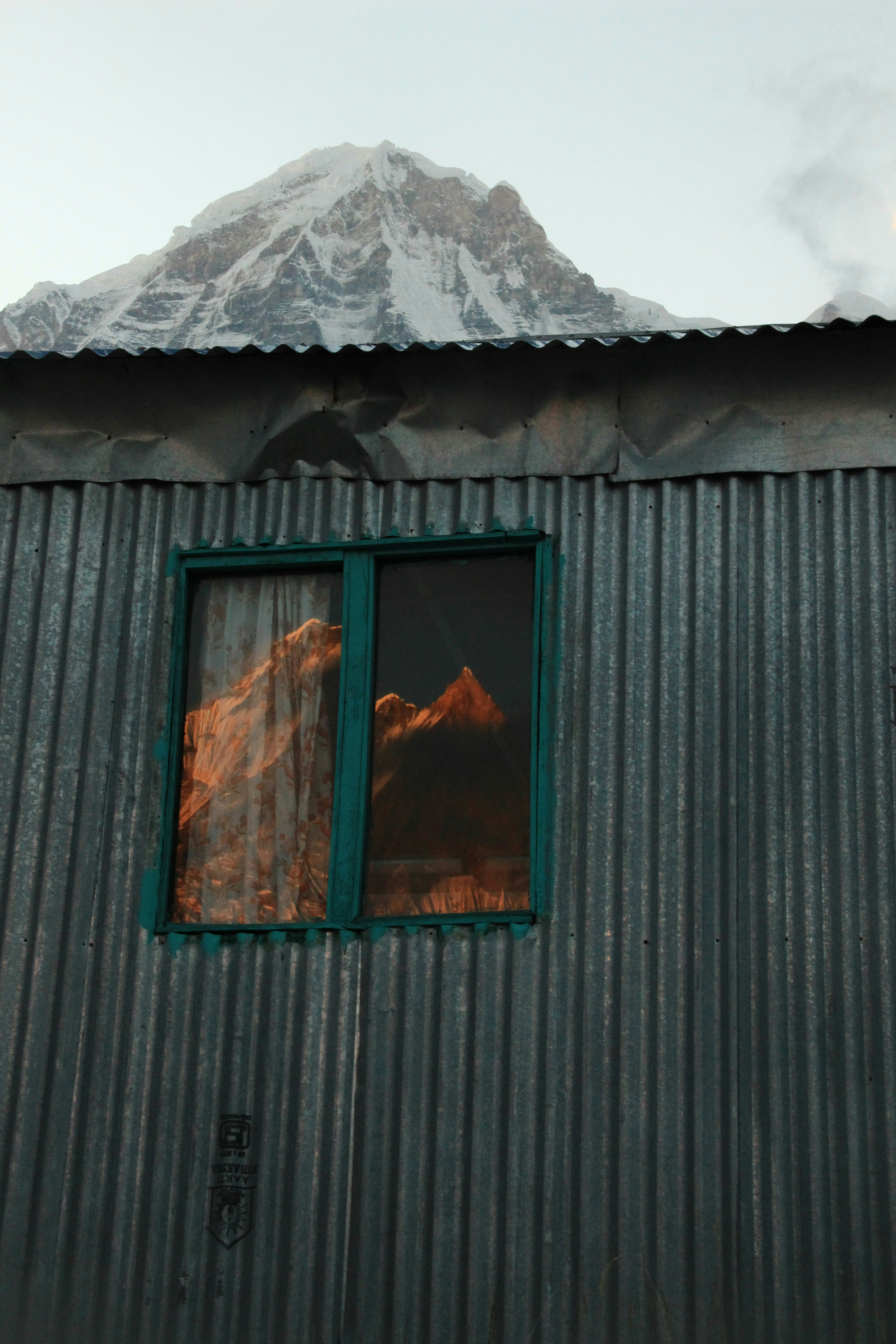 Schneebedeckter Berg, der sich in einem Fenster spiegelt