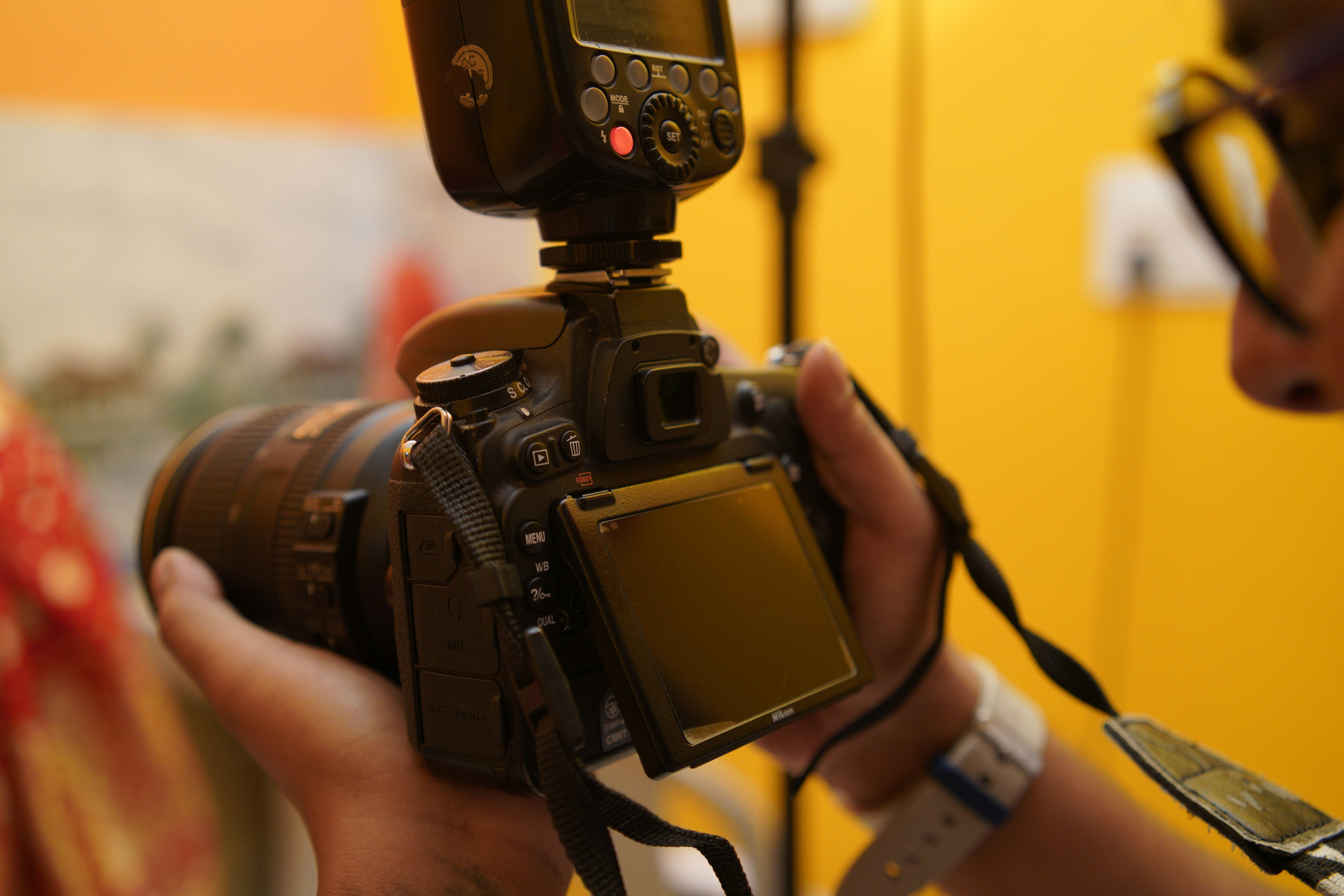 Photographer holding a camera with an external flash