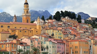 Colorful buildings on a hillside with mountains behind.