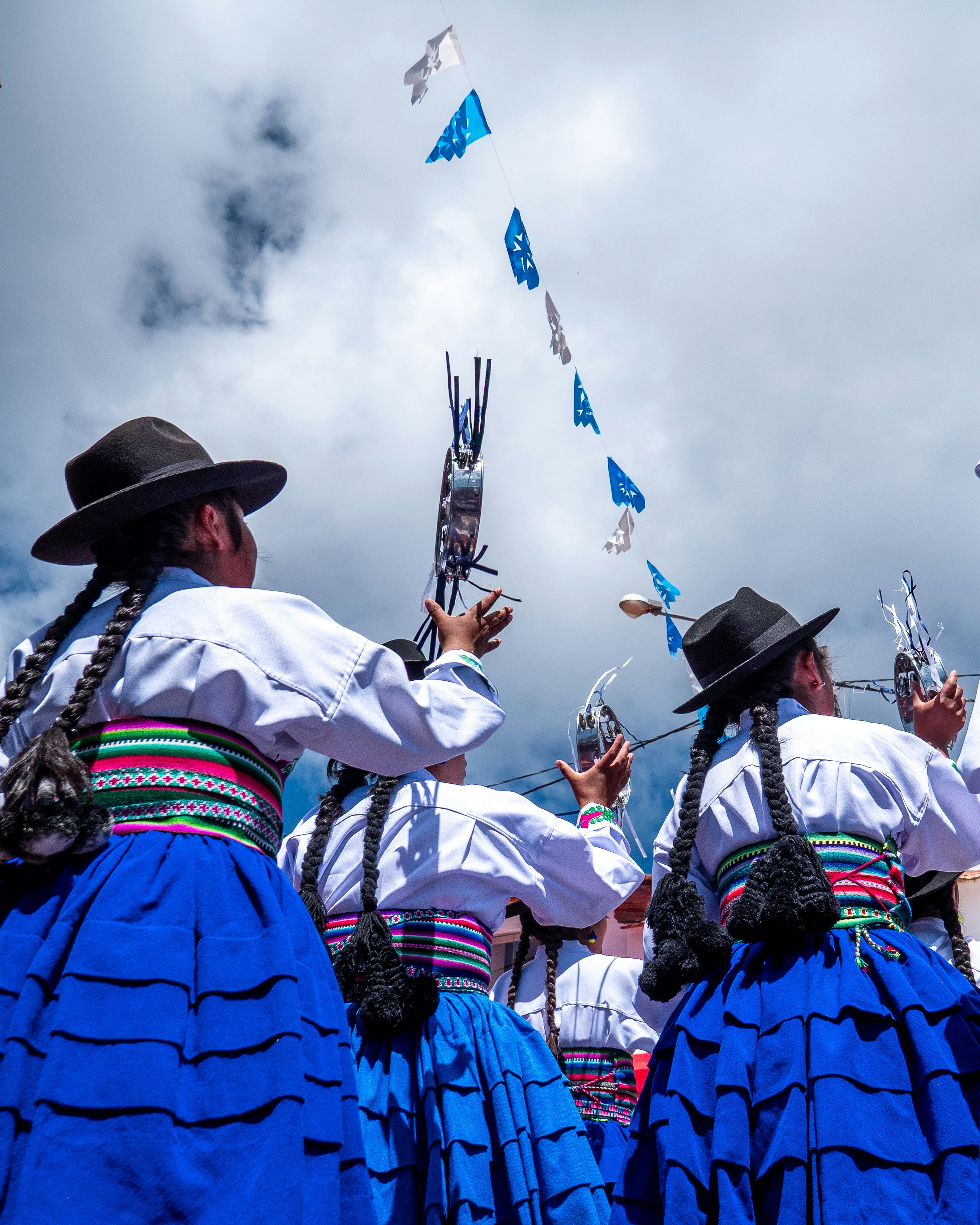 Women in traditional dress celebrate with flags
