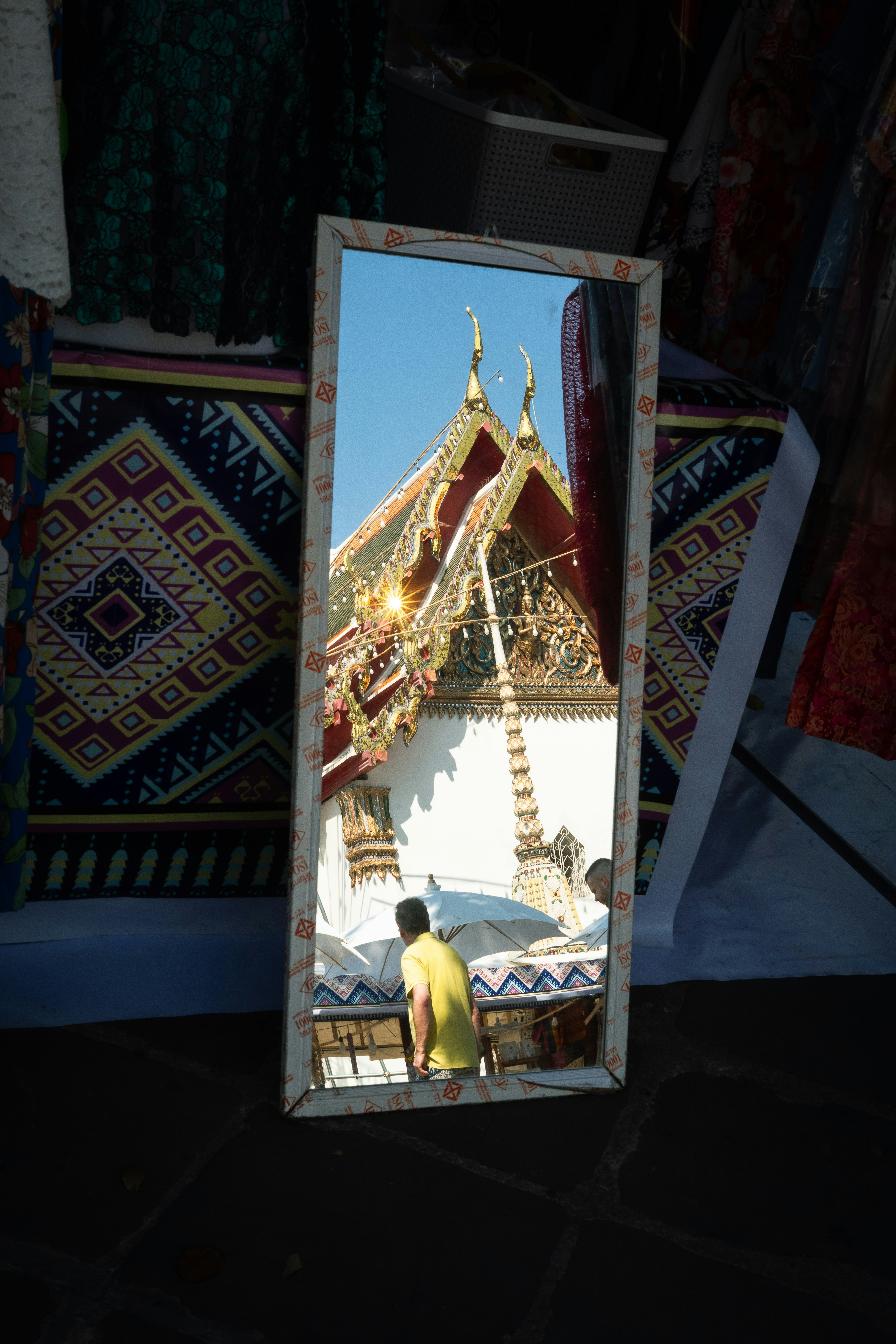 Mann beobachtet Tempelspiegelung im Spiegel