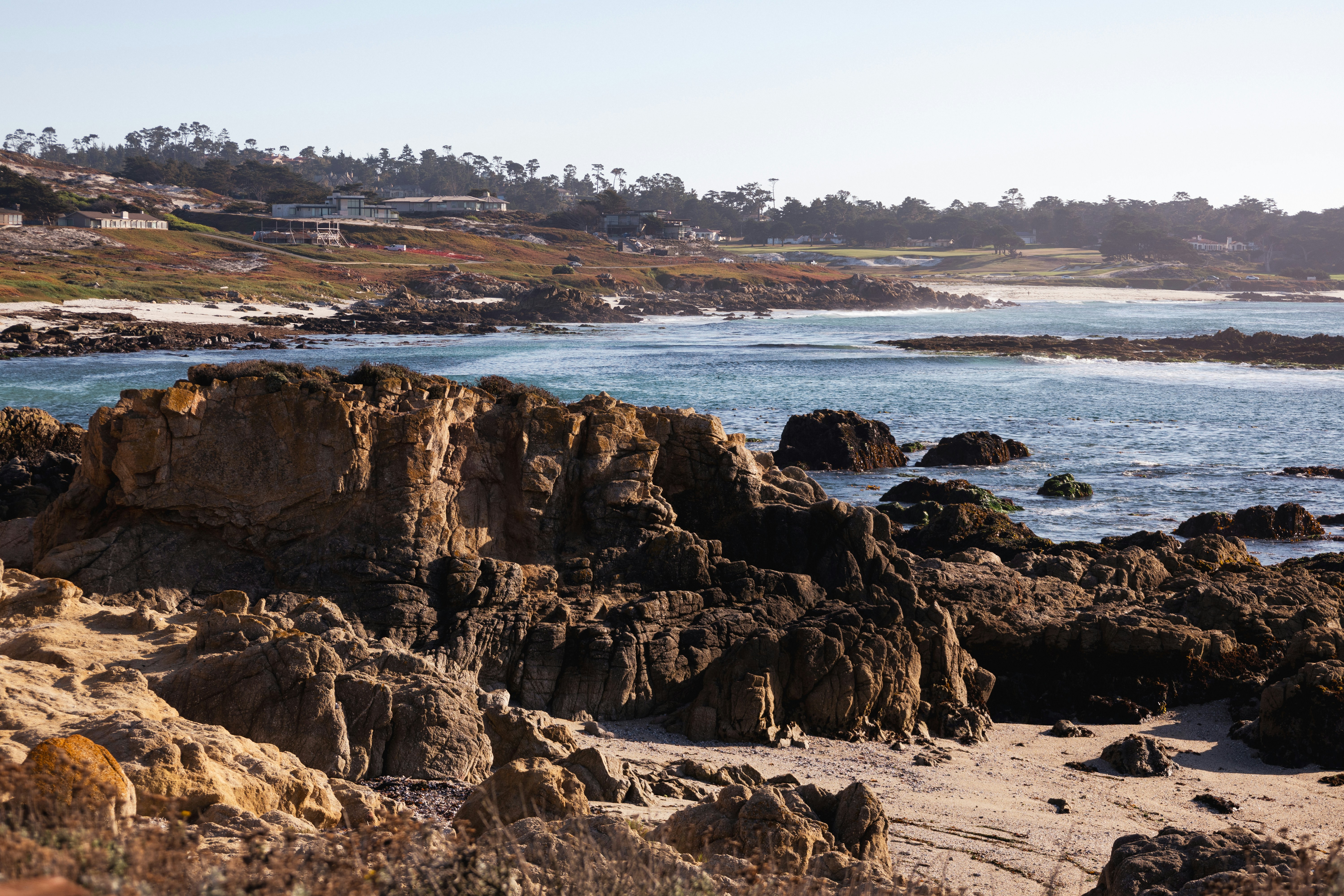 Rocky coastline with ocean and distant homes