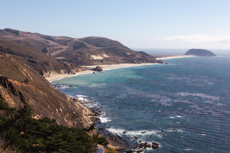 Rugged coastline with ocean waves and distant island