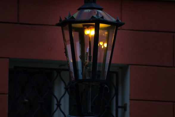 An old-fashioned lantern glows warmly at dusk.