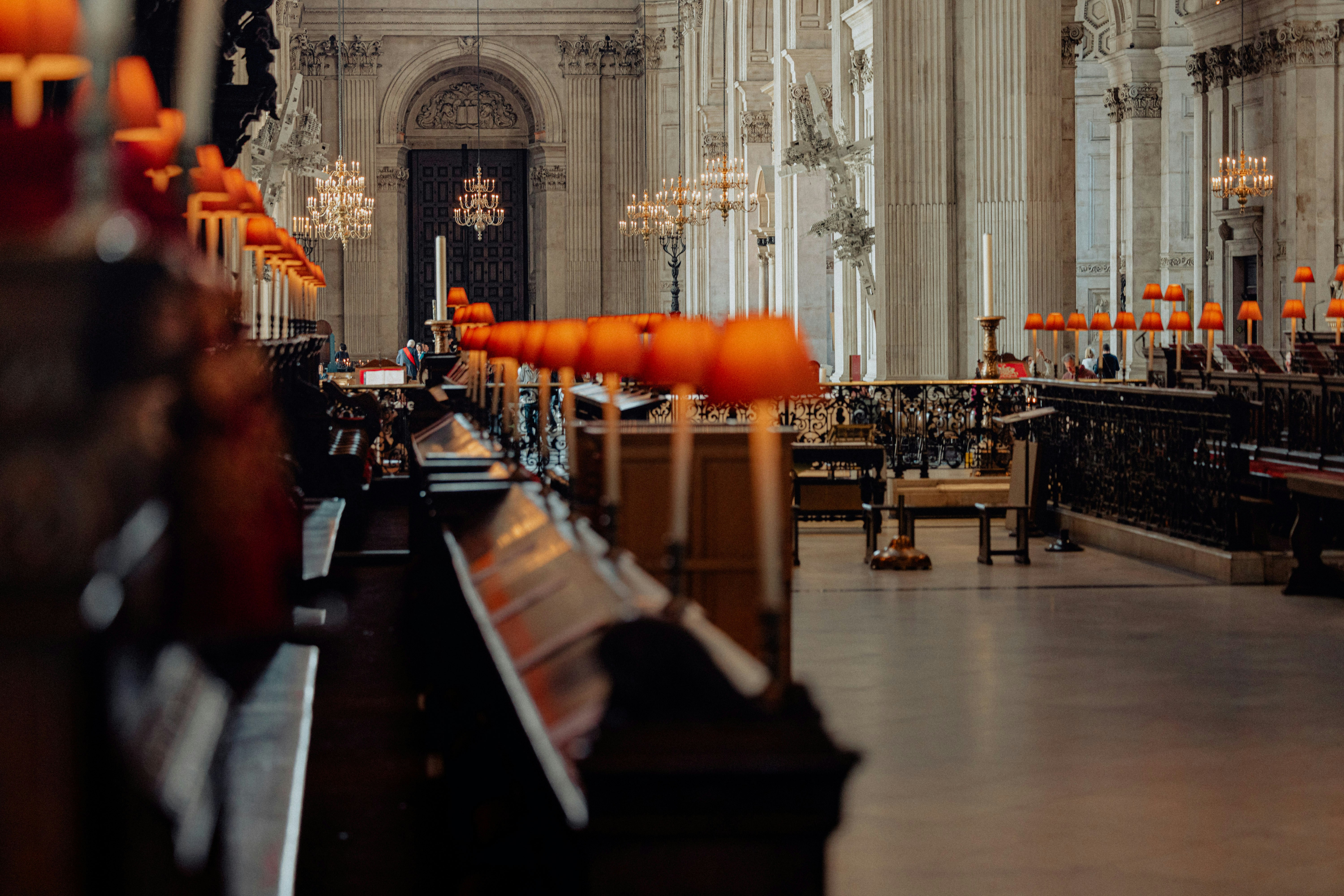 Rows of ornate wooden pews inside a grand cathedral.