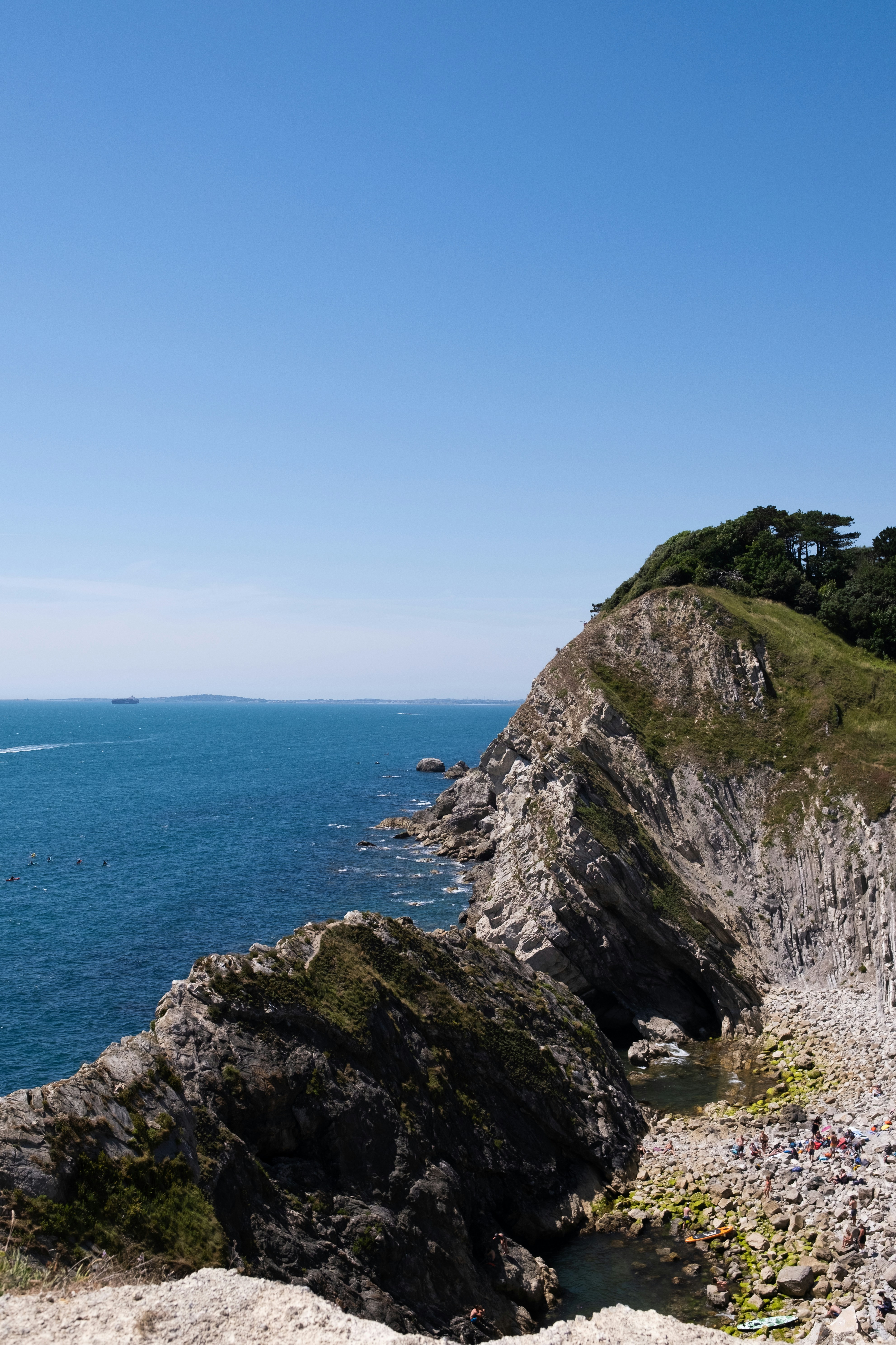 Rocky coastline with the blue ocean under clear sky
