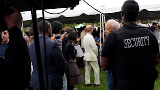 Security guard watches over a gathering under a tent