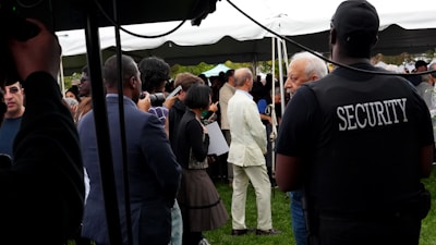 Security guard watches over a gathering under a tent