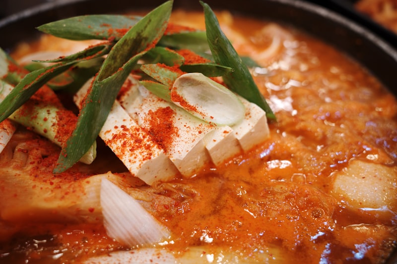 A bubbling bowl of doenjang jjigae with tofu and scallions