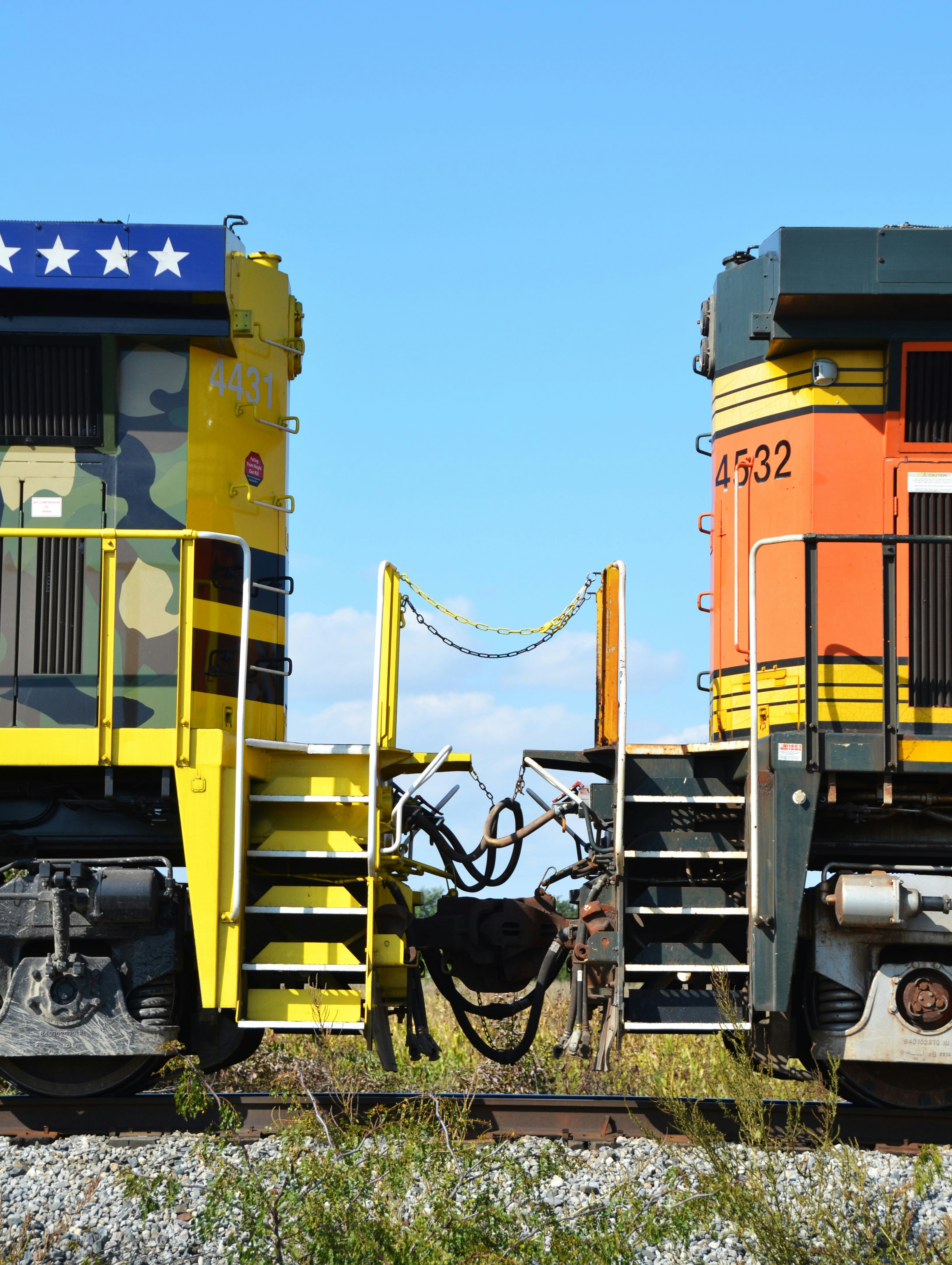 Two trains facing each other under a clear blue sky.