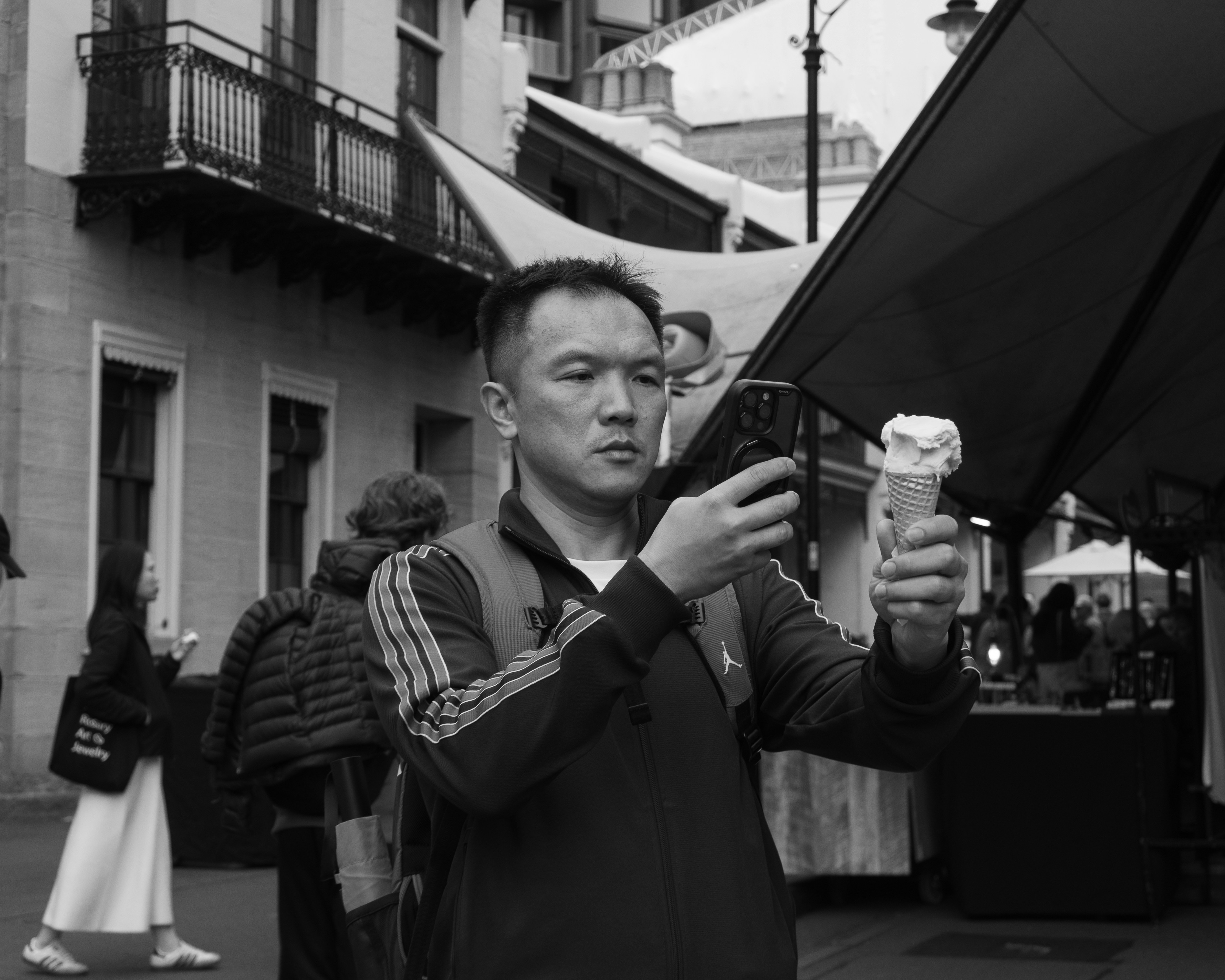 Man holding ice cream and phone at market