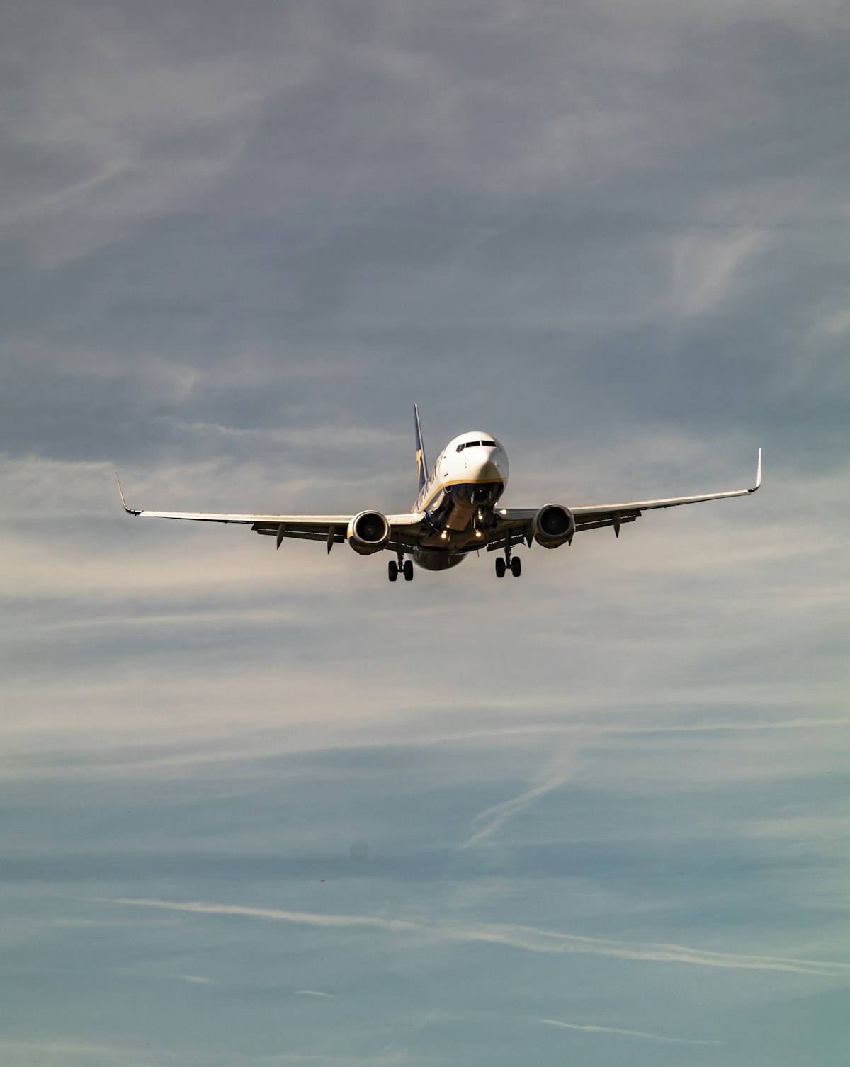 A commercial airplane flying through a cloudy sky