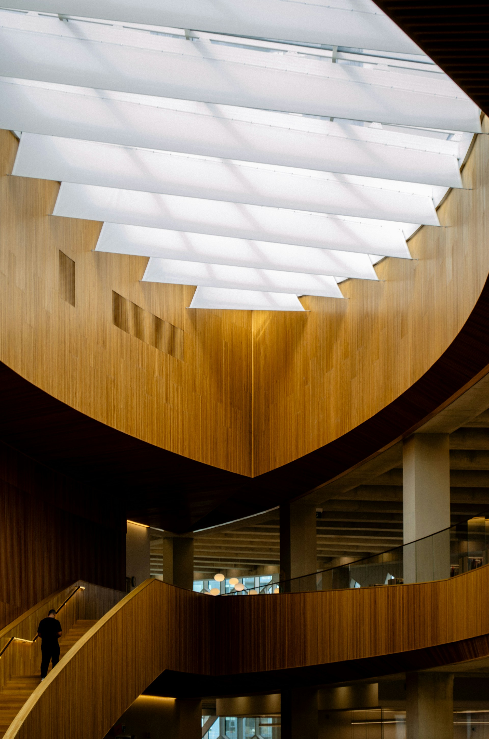 Modern wooden interior with geometric ceiling and staircase