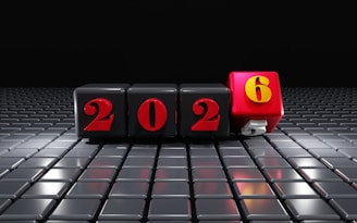 Black cubes with red numbers 2026 on textured surface