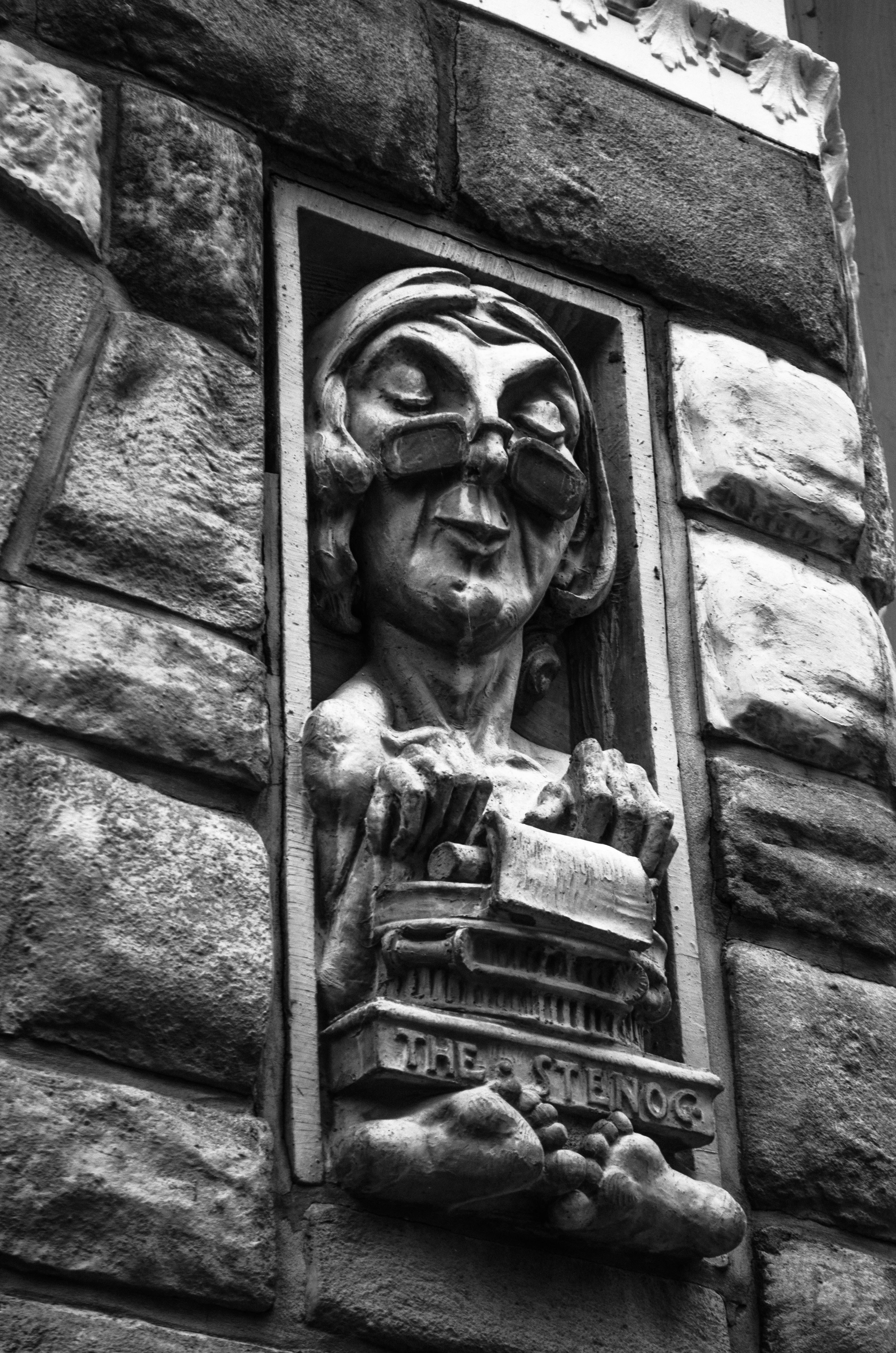 Carved relief of a person typing on a typewriter.