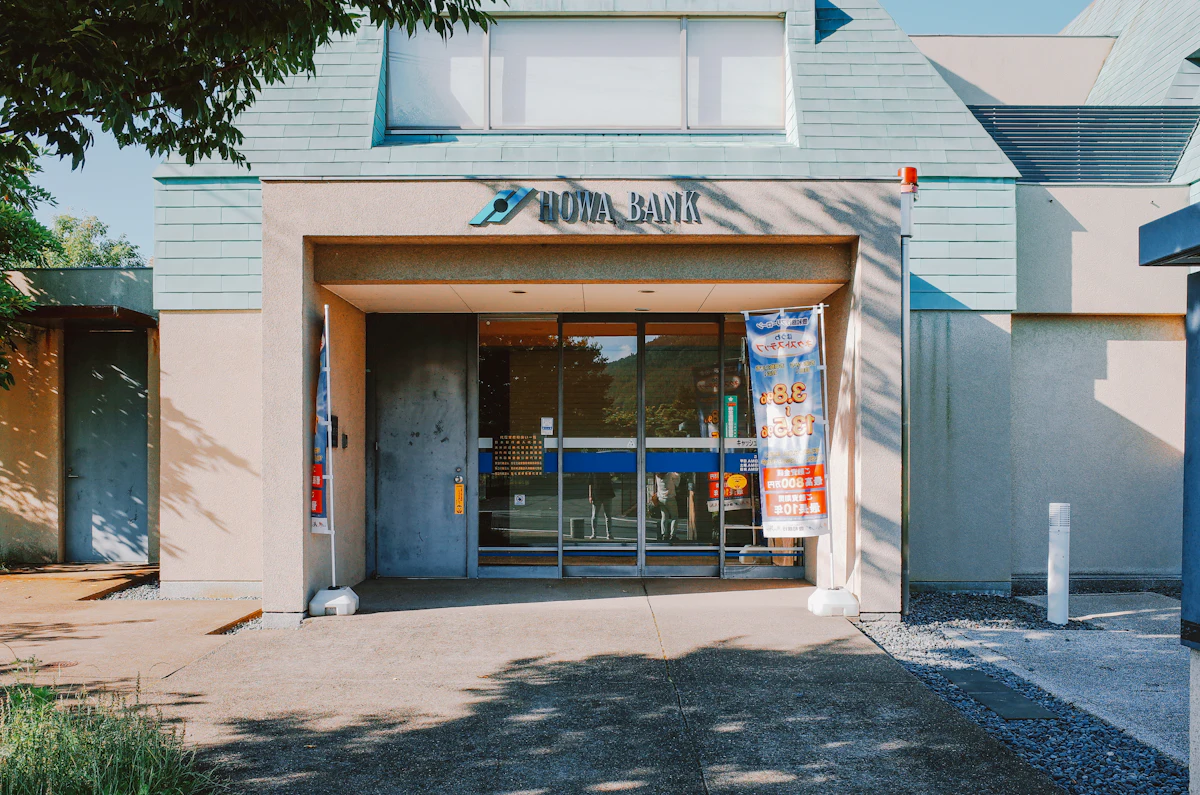 Modern bank entrance with glass doors on a city street