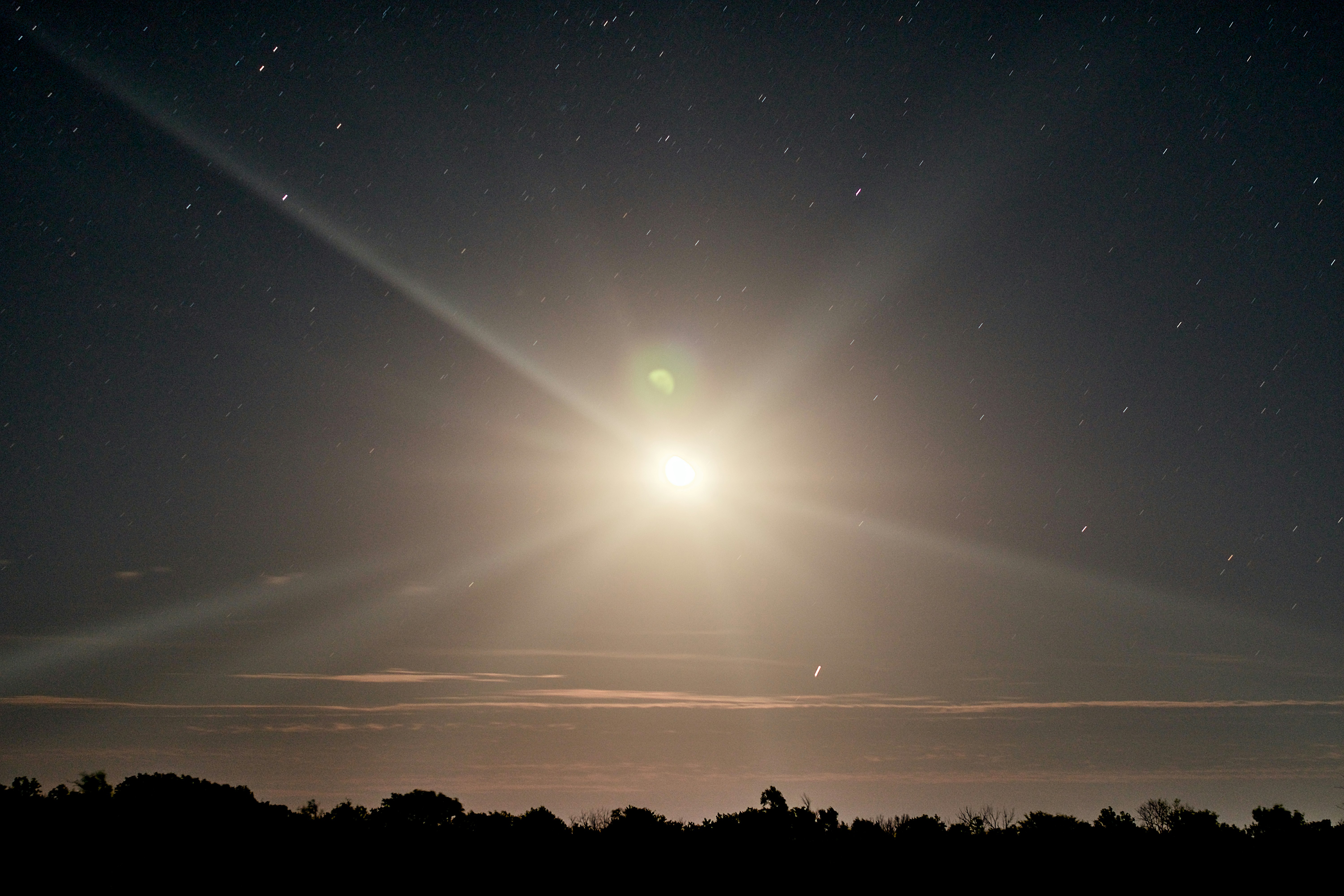 Bright moon illuminates the night sky with stars.