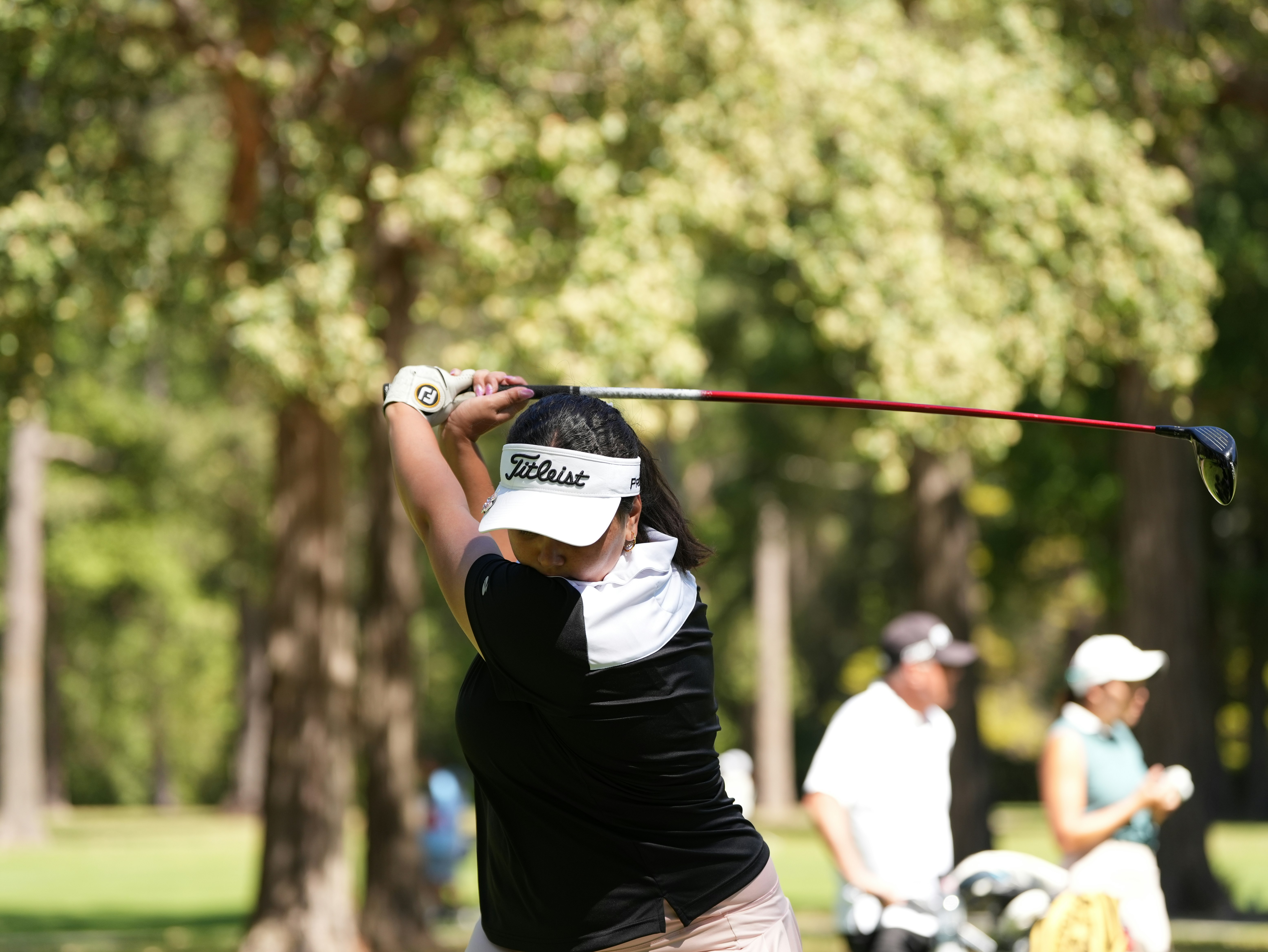 Golfer swings club on a sunny day