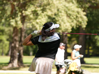 Woman swinging golf club on sunny day