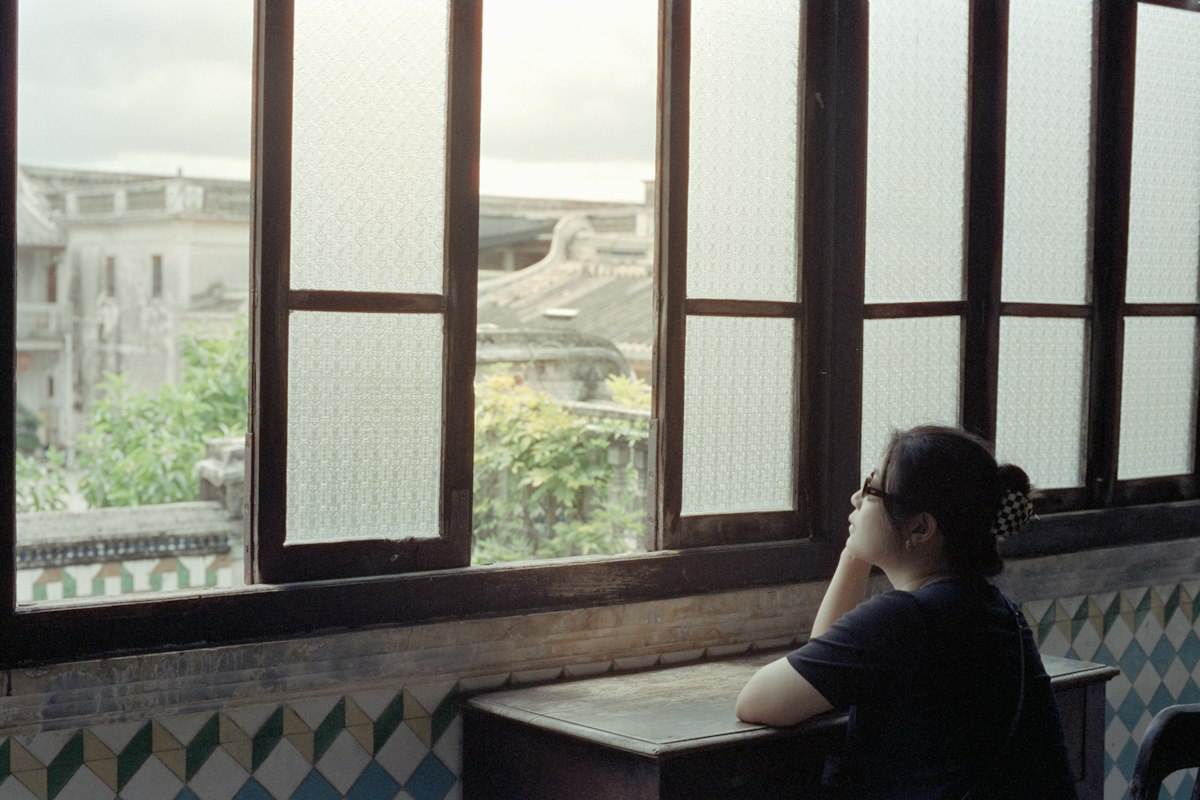 Femme regardant par la fenêtre, en retrait