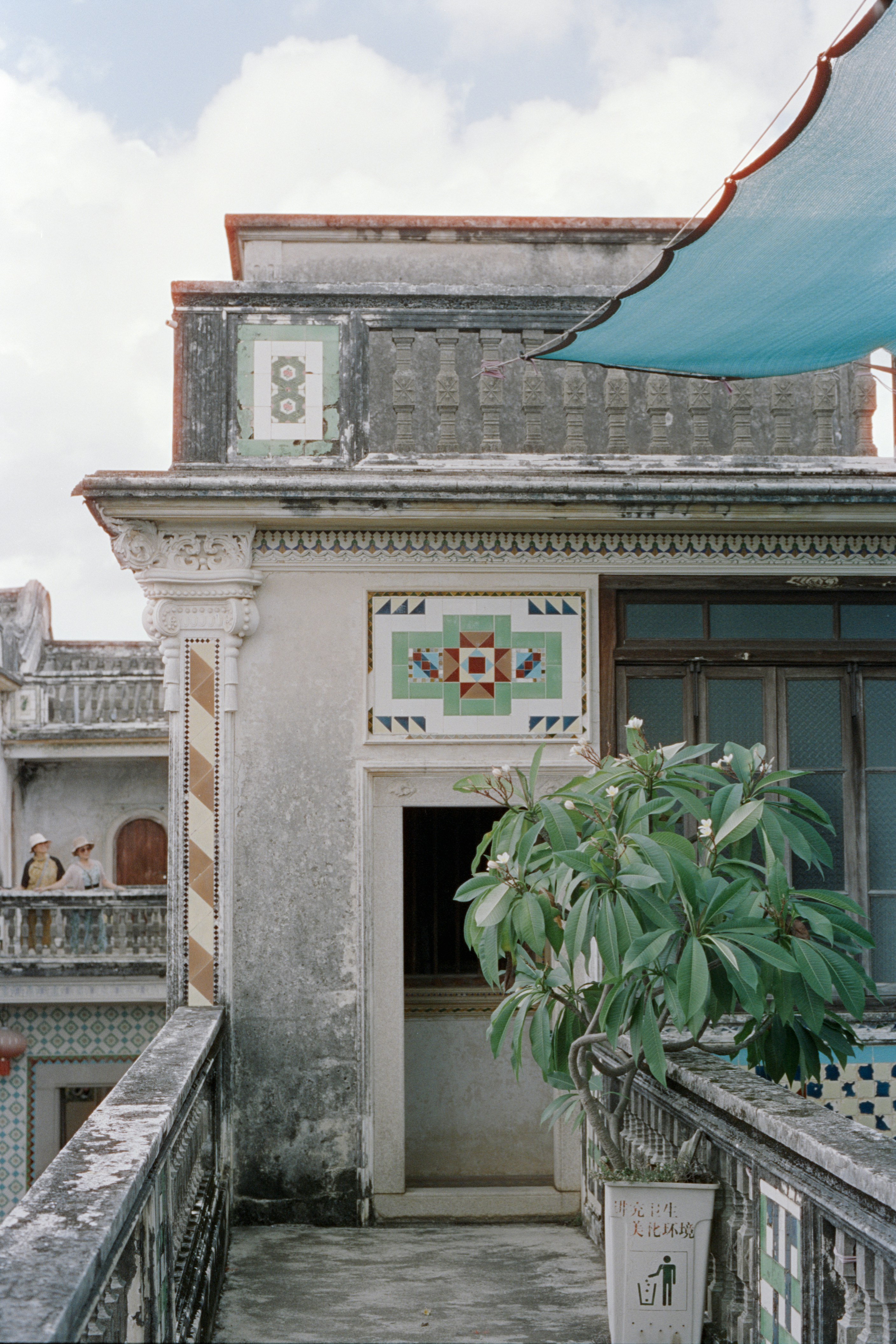 Fachada ornamentada del edificio con azulejos decorativos y plantas.