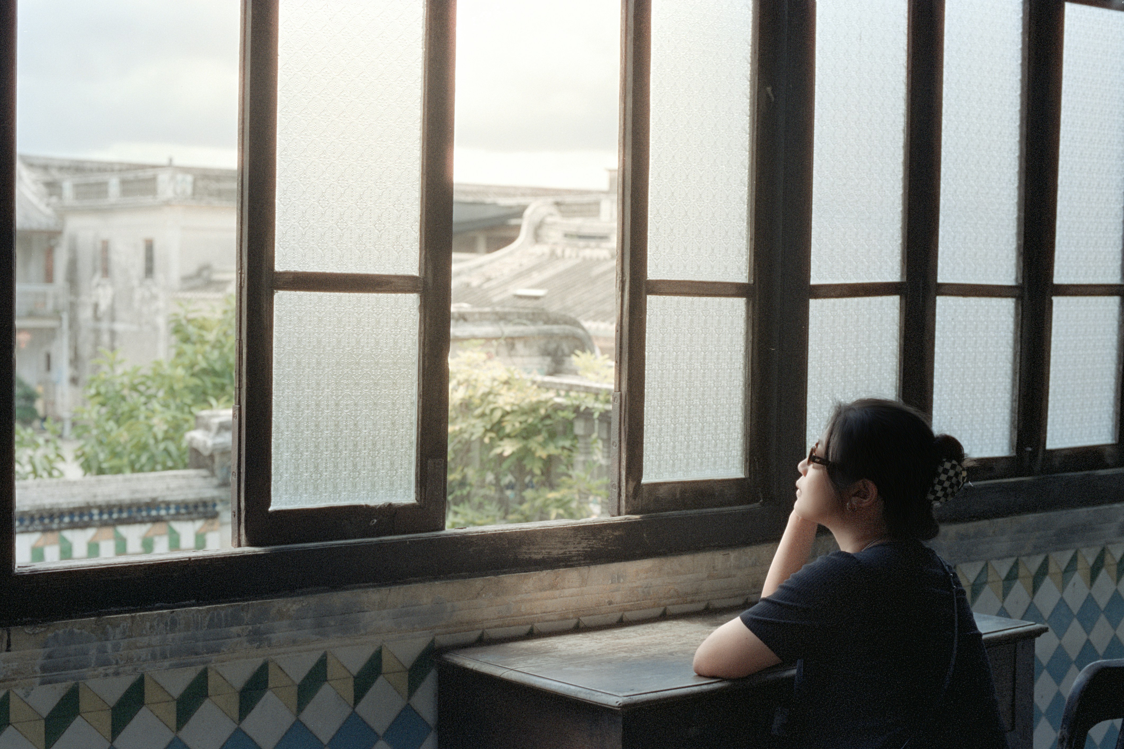 Woman looking out a window at buildings