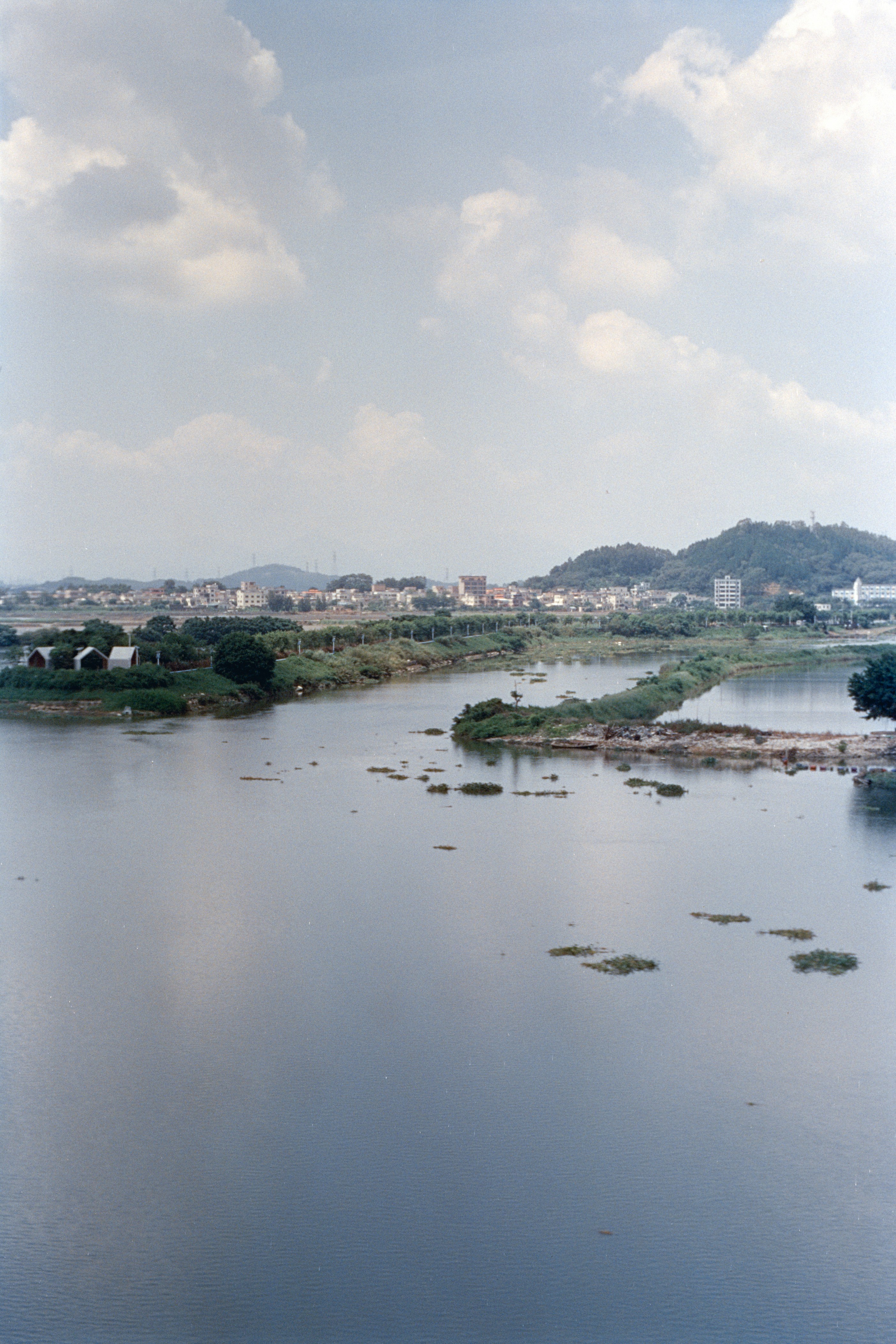Calm river flowing through a landscape with distant hills.