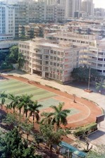 School buildings with athletic field and palm trees.