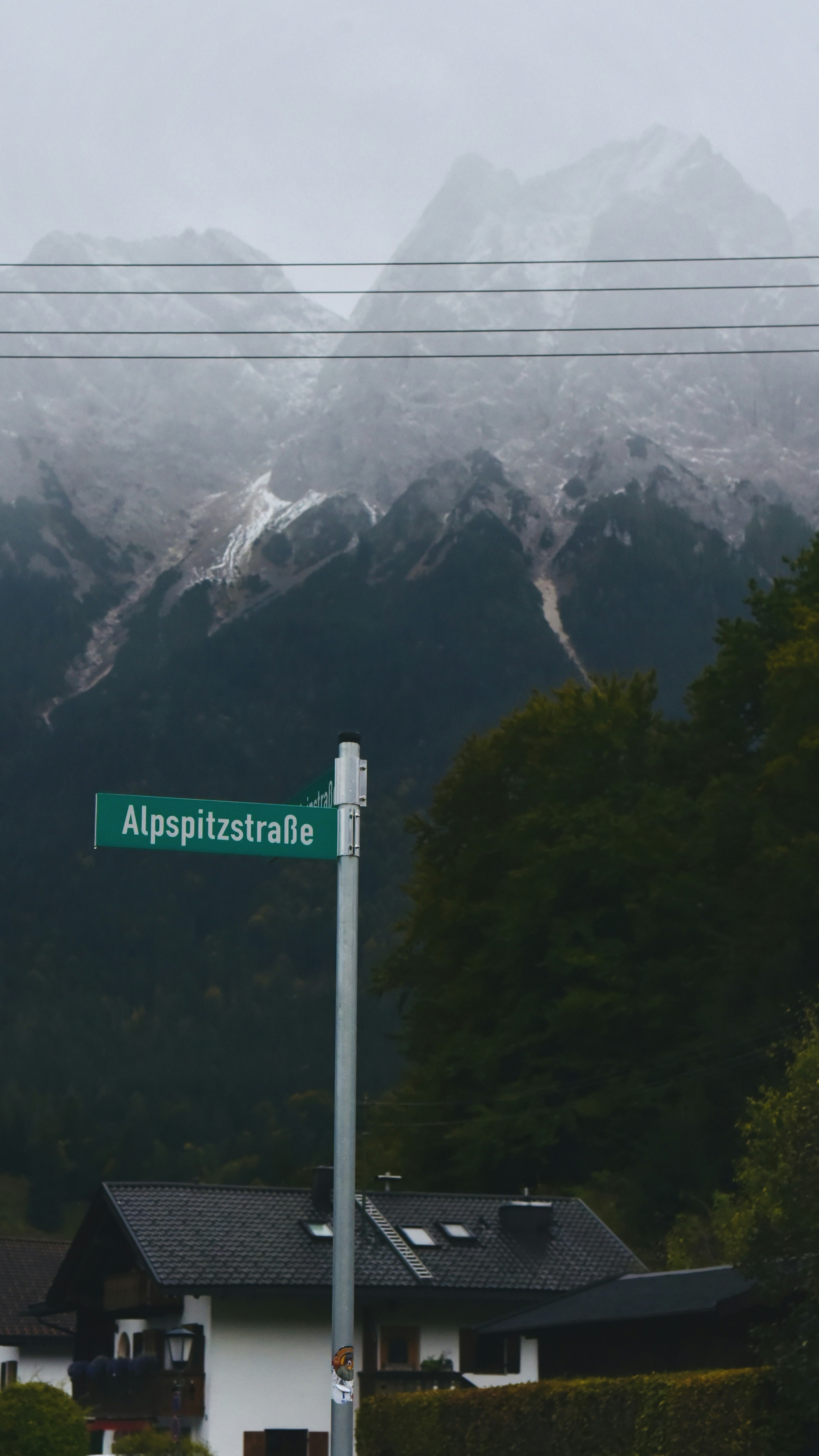 Street sign in front of misty mountains and houses